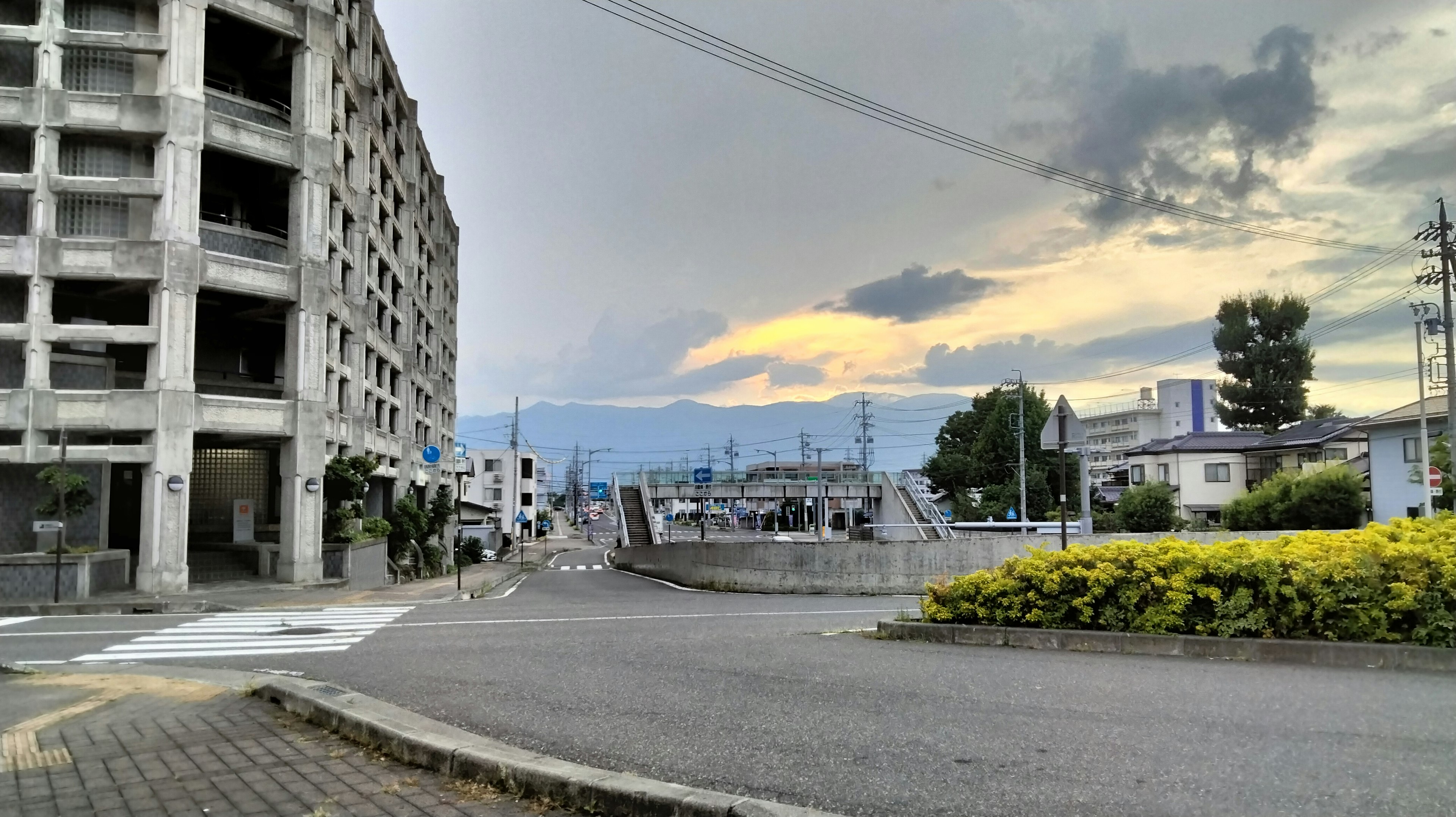 Urban street view under cloudy sky with distant mountains