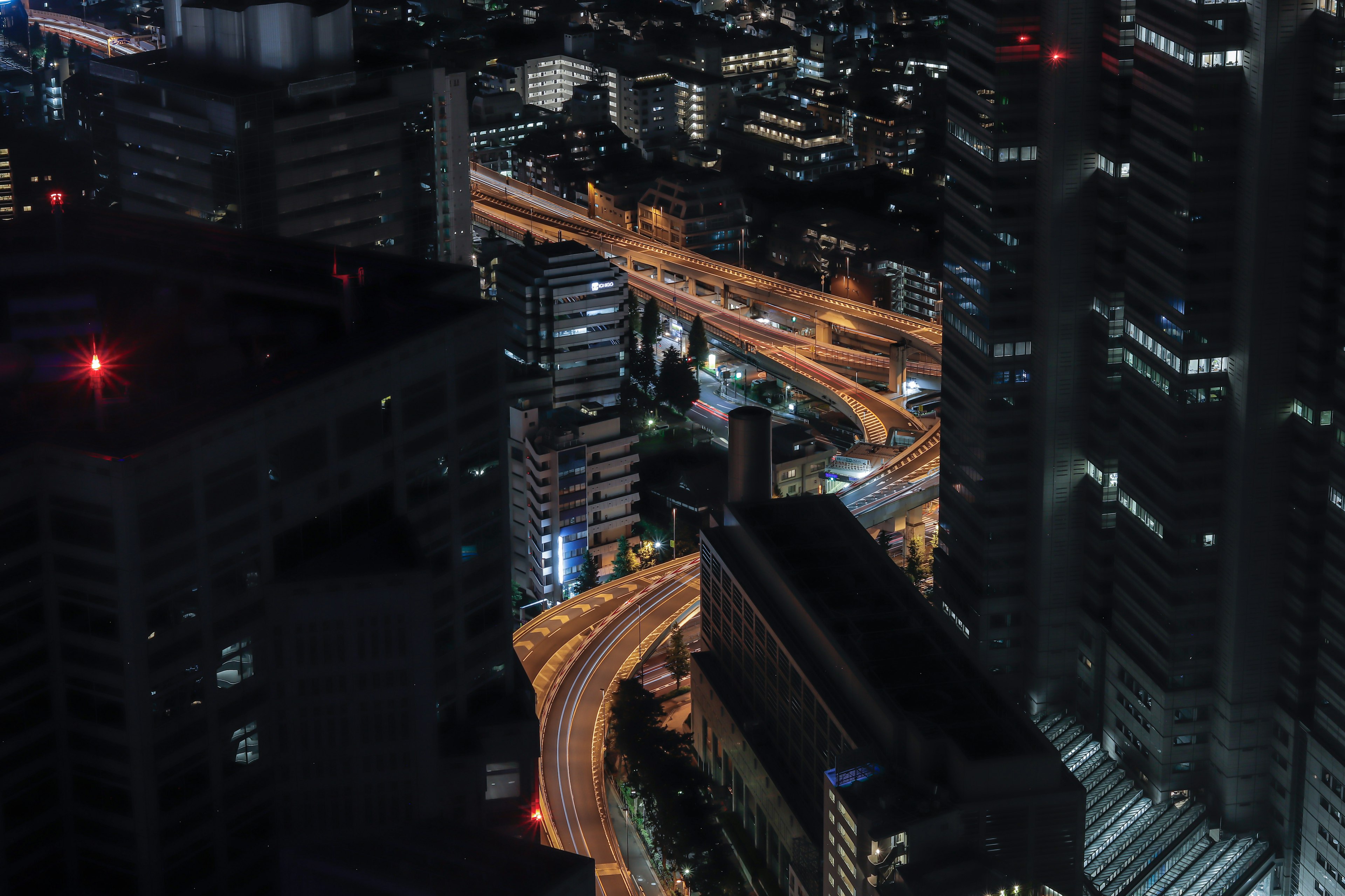 Night cityscape featuring illuminated highways and buildings