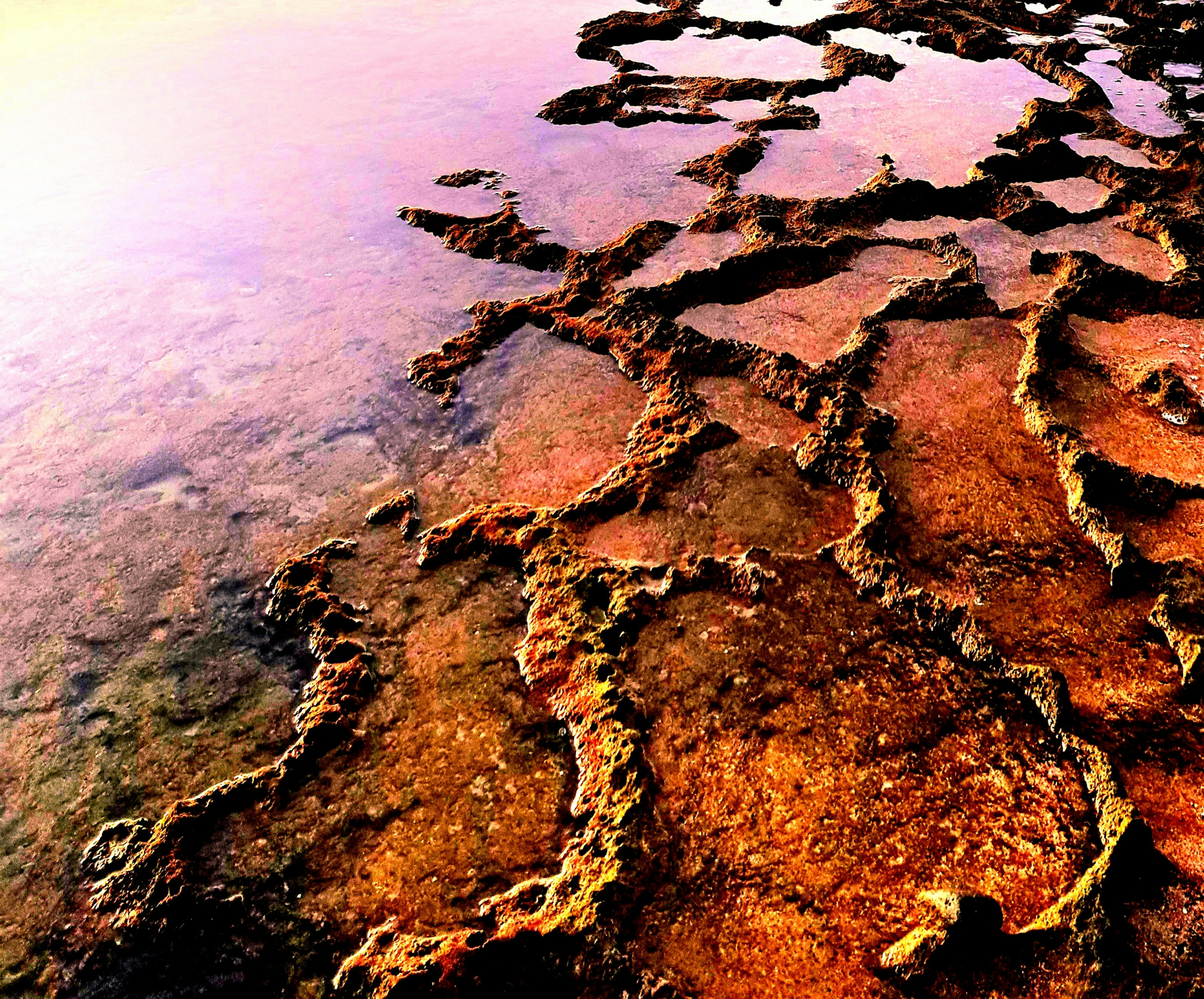 Muster und Farben von Felsen, die sich auf der Wasseroberfläche spiegeln