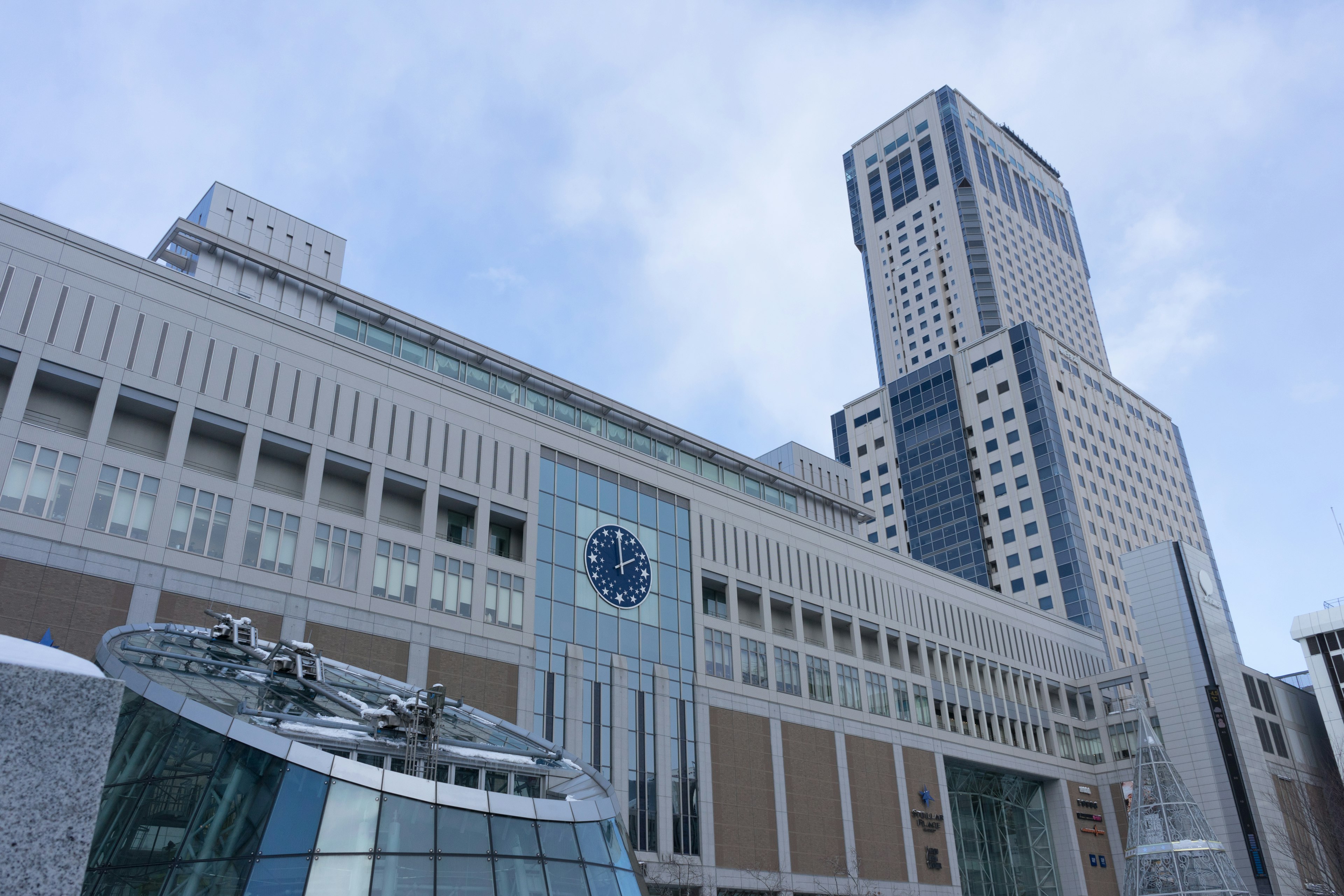 Vista exterior de un edificio moderno con torre del reloj y rascacielos