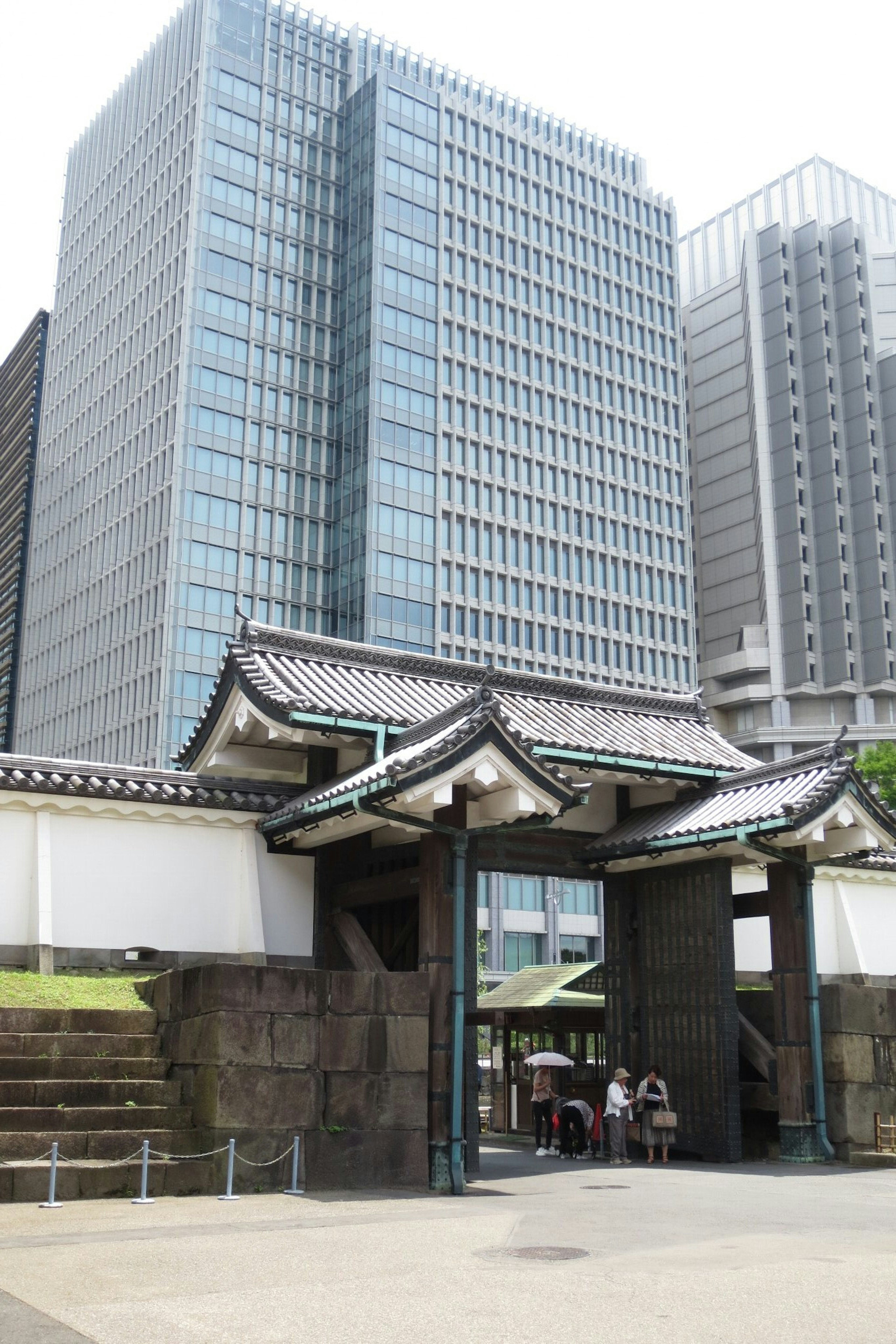 A scene featuring modern skyscrapers alongside a traditional Japanese gate