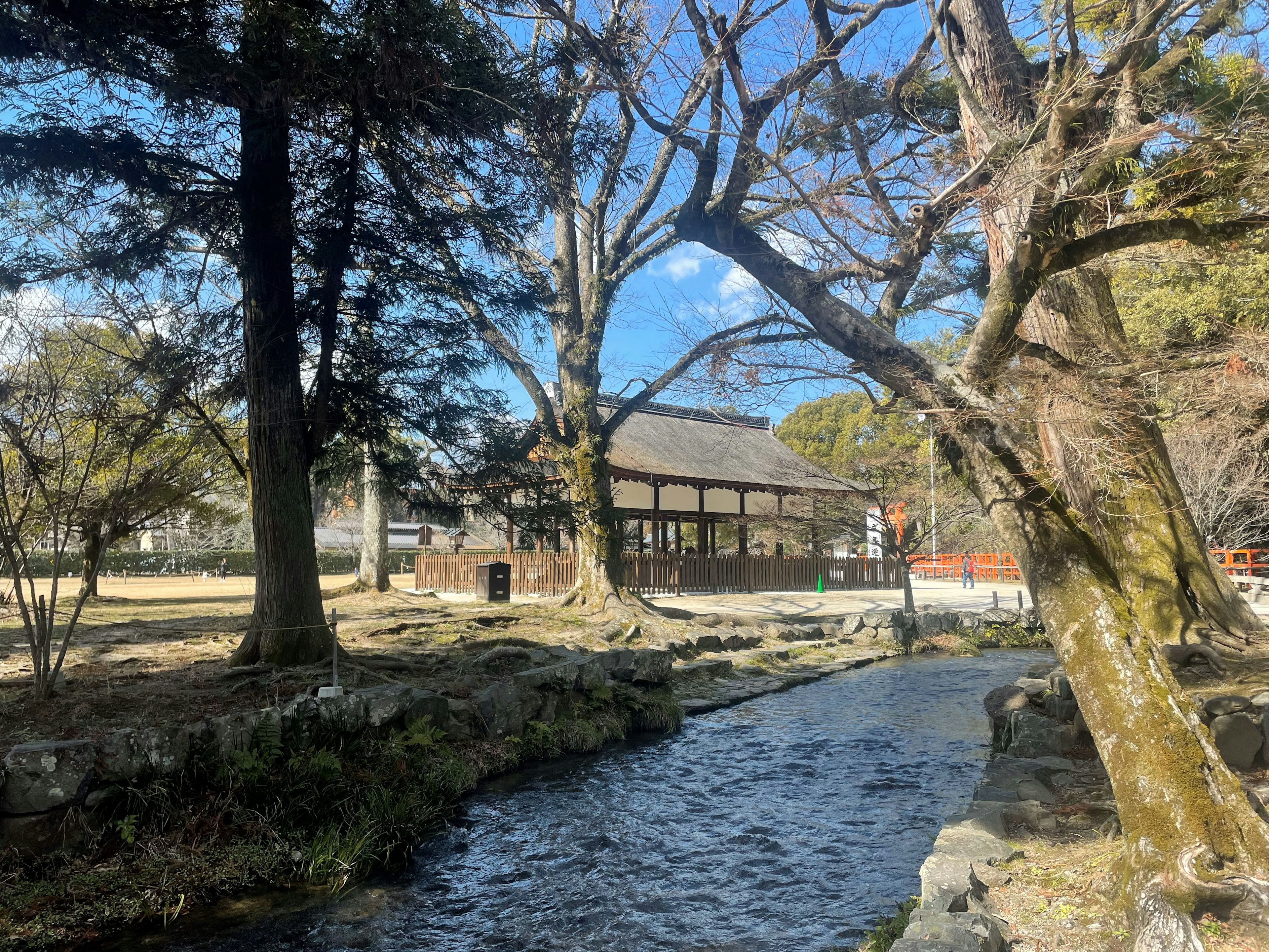 Scenic view of a traditional building by a river with trees