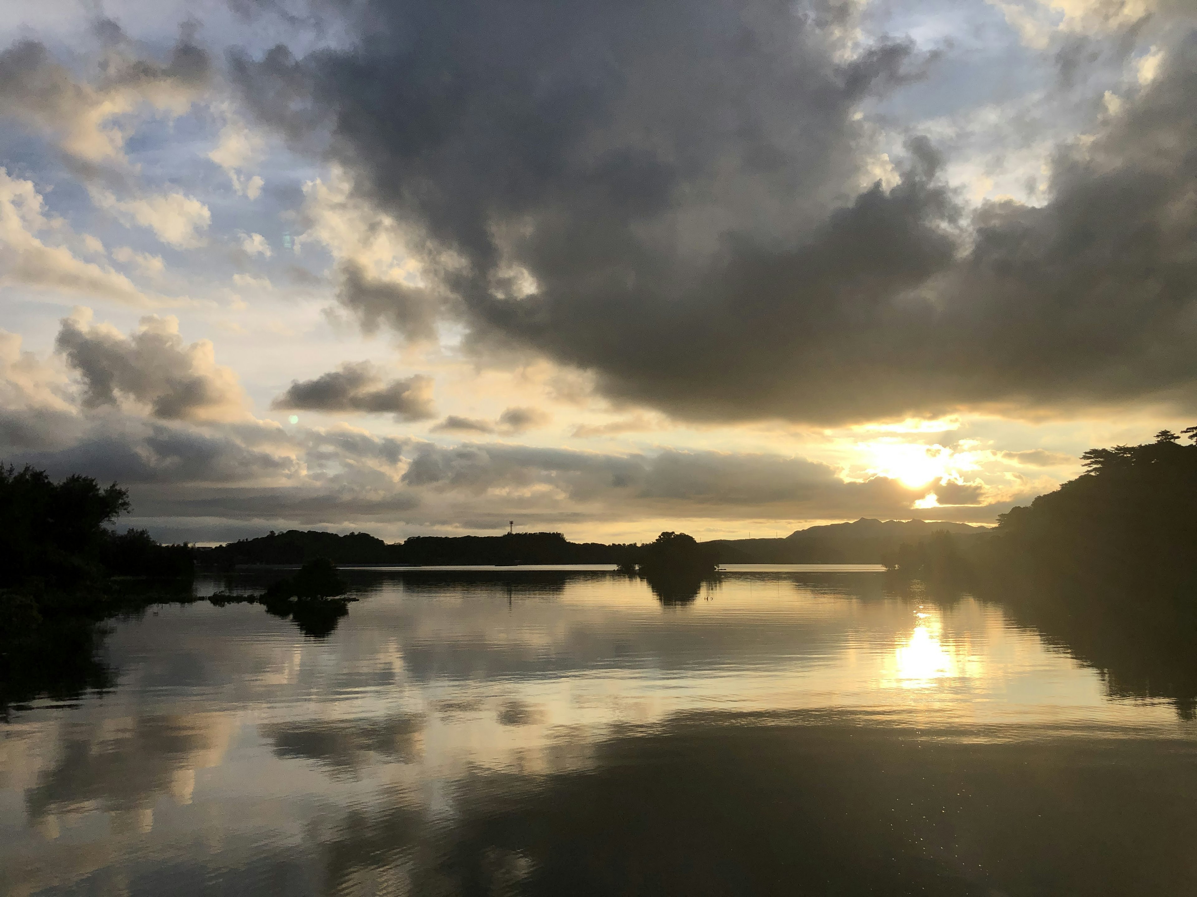 Senja tenang di danau dengan refleksi awan