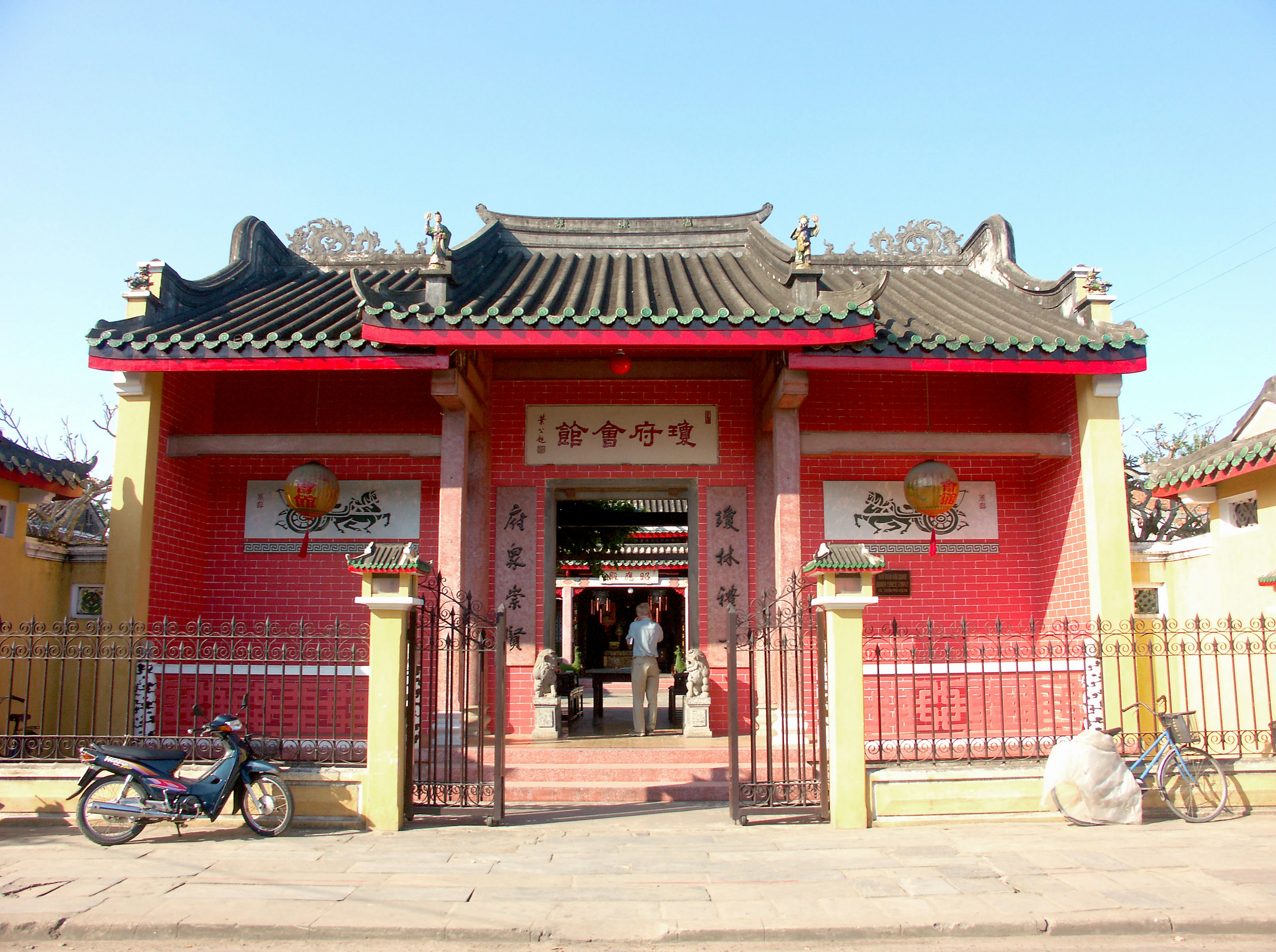 Exterior view of a temple with red walls and traditional roof