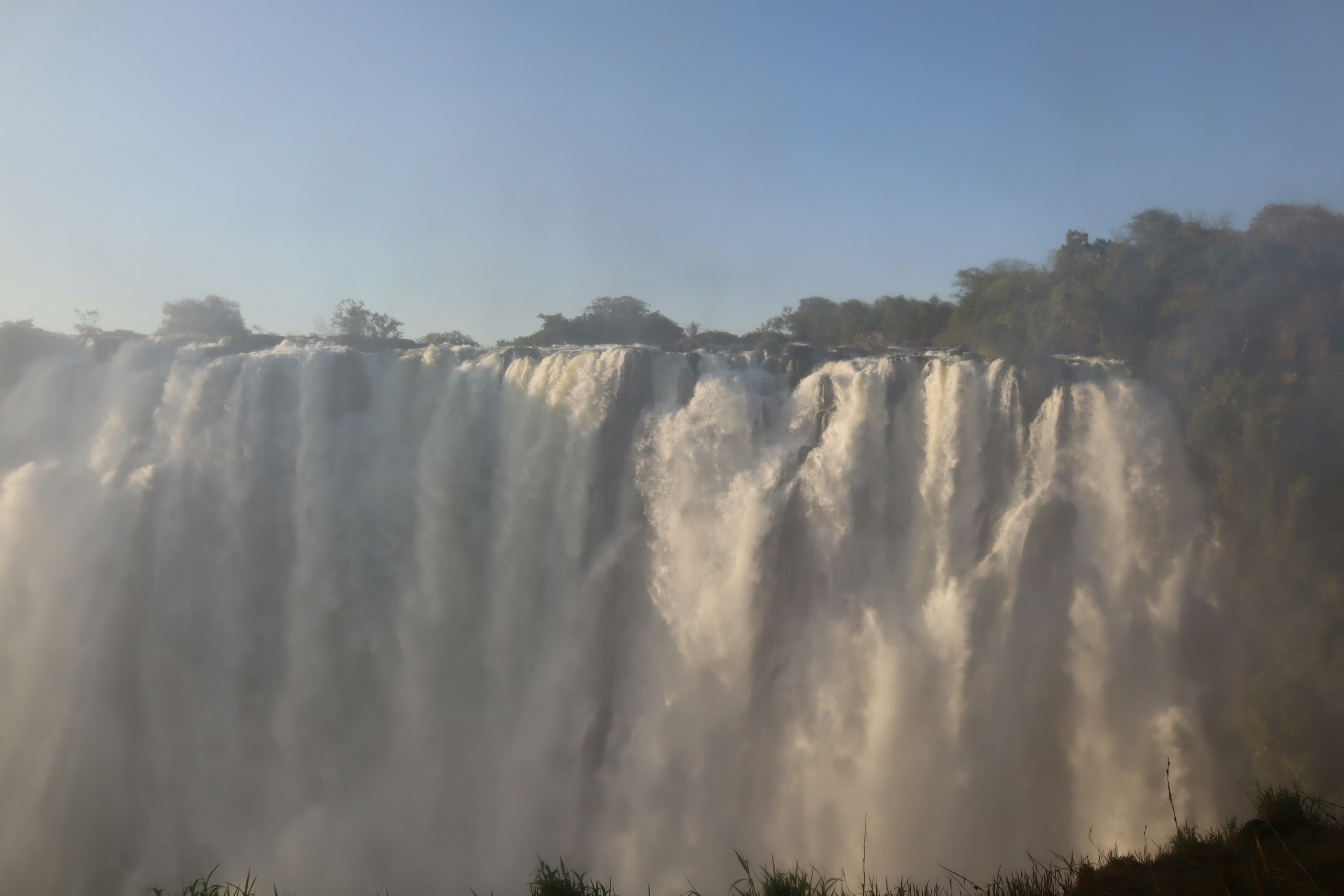 Vue majestueuse de la cascade avec ciel bleu et arbres verts