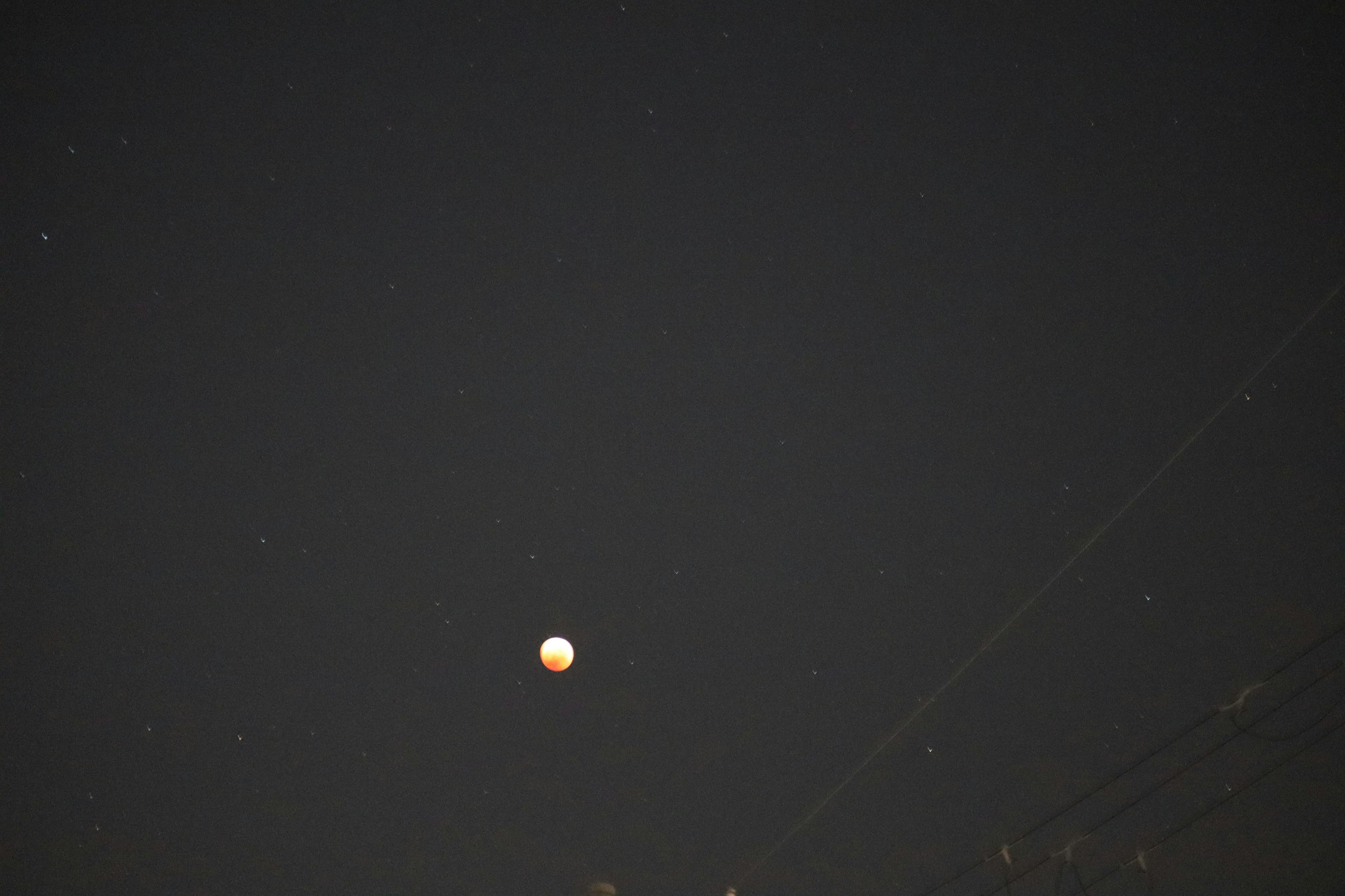 Esfera naranja flotando en el cielo nocturno