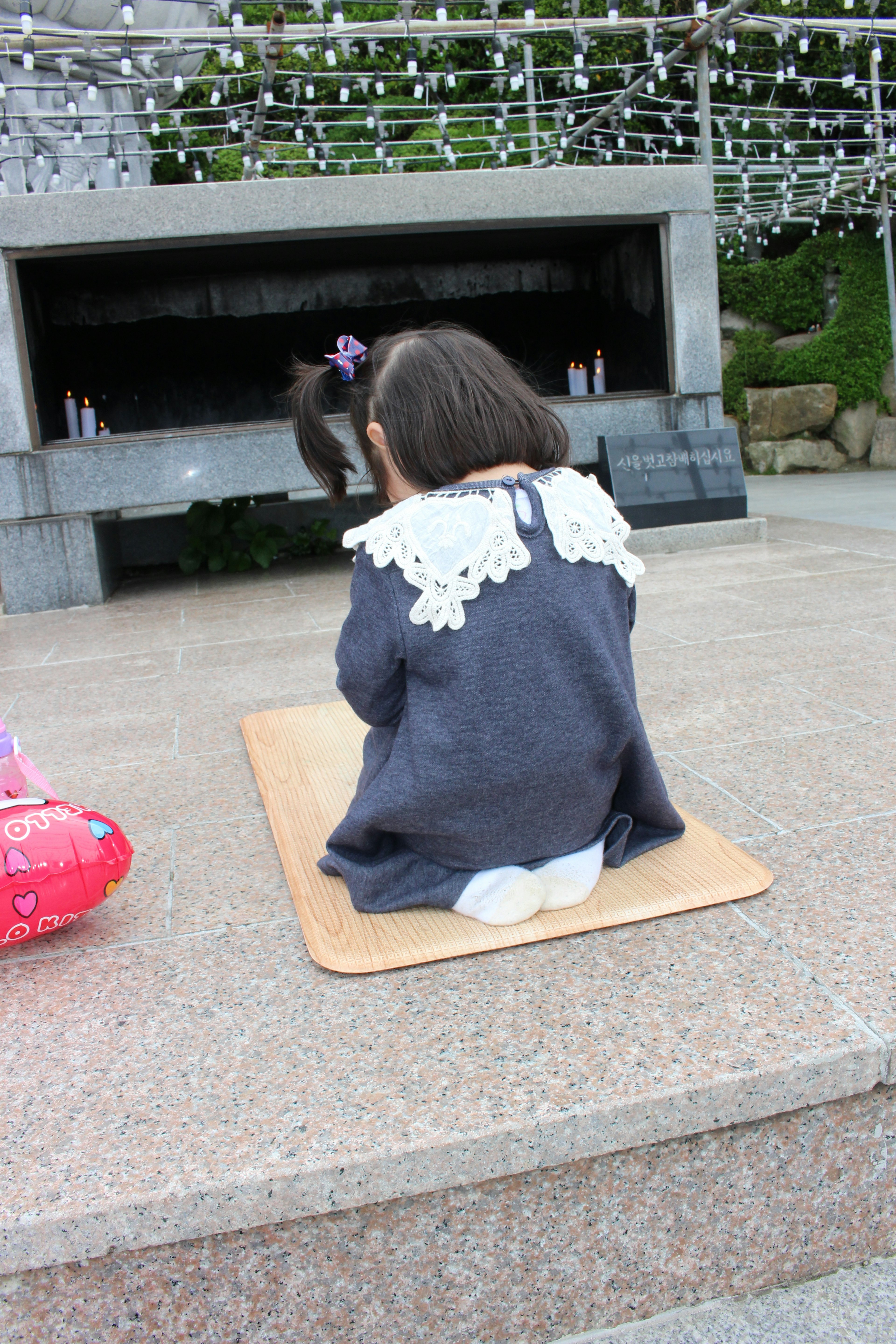 Enfant assis sur un tapis avec un pull décoratif à col en dentelle