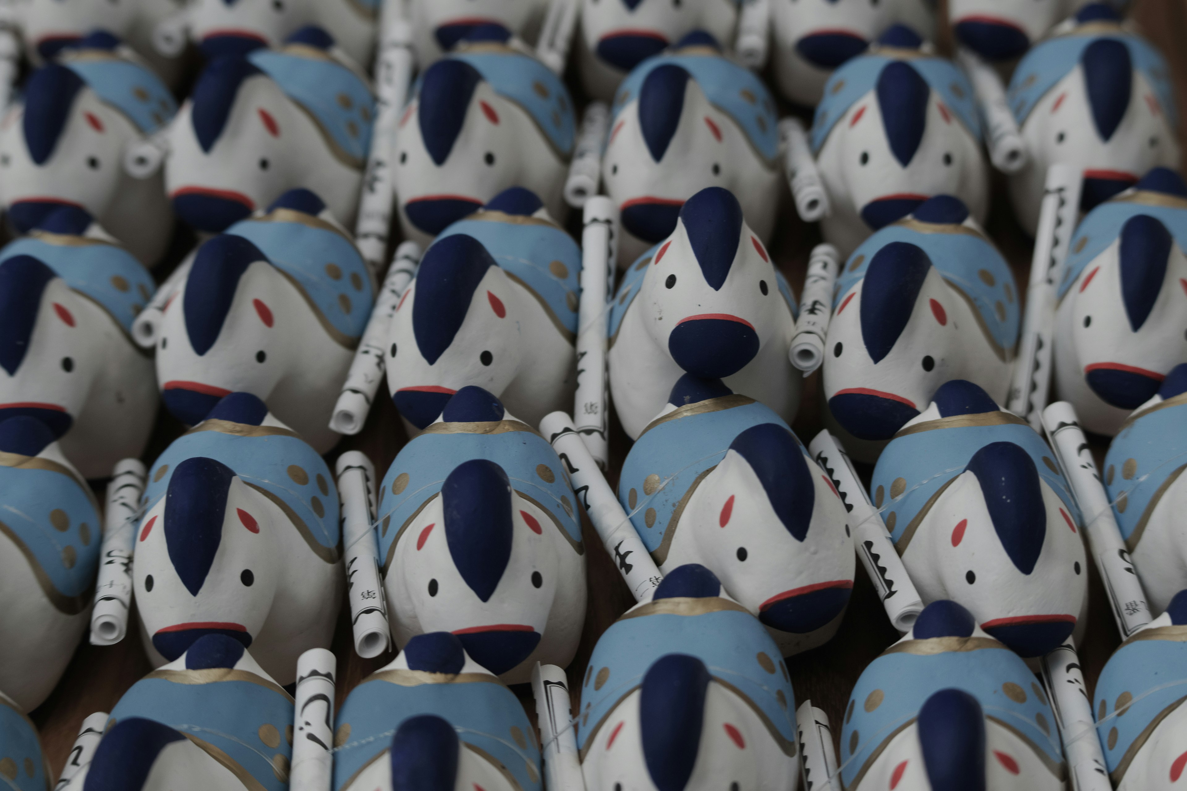 A collection of small blue and white dog figurines arranged in neat rows