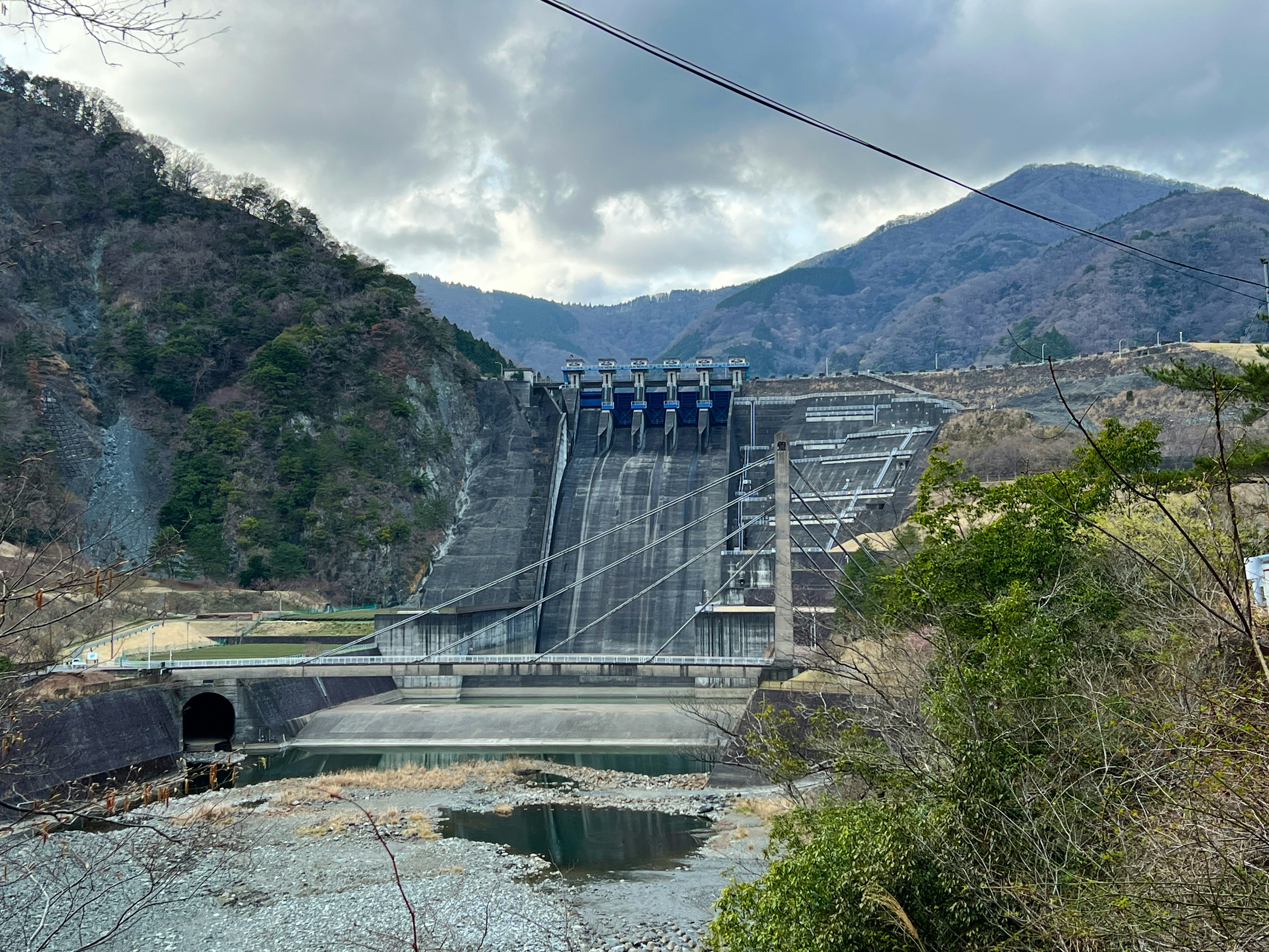 Estructura de presa rodeada de montañas con agua fluyendo