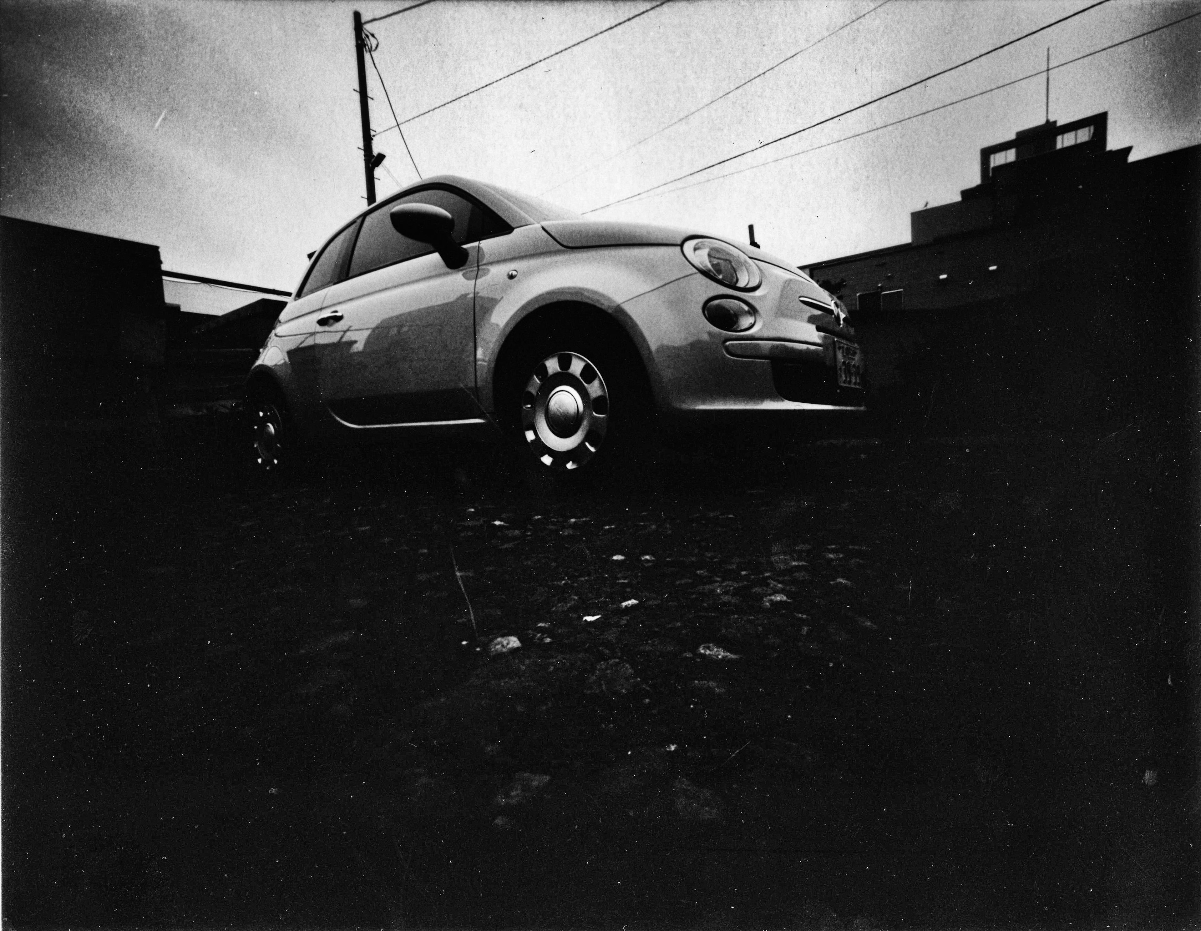 A small car in a black and white setting with a moody atmosphere