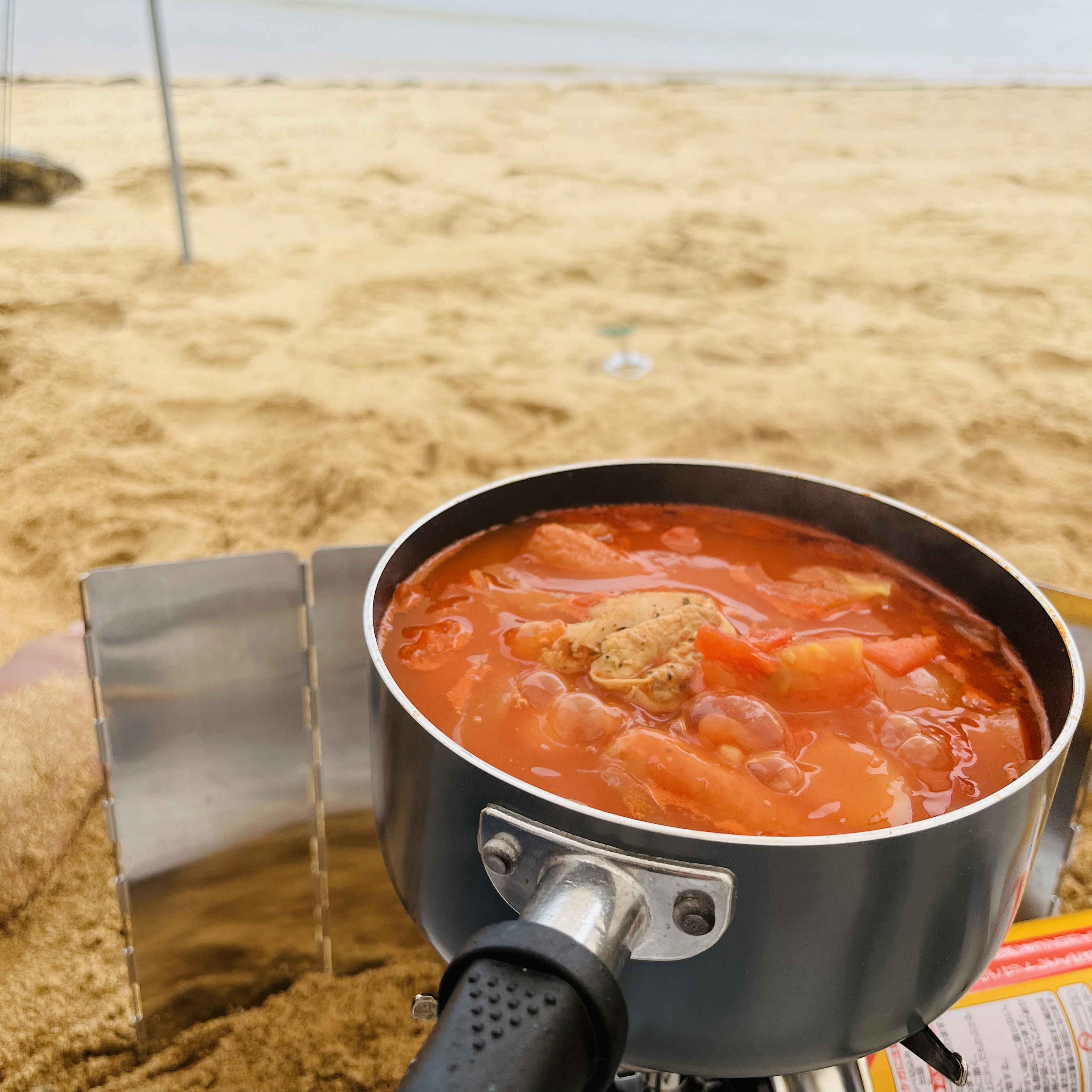 ビーチで料理されているトマトスープの鍋