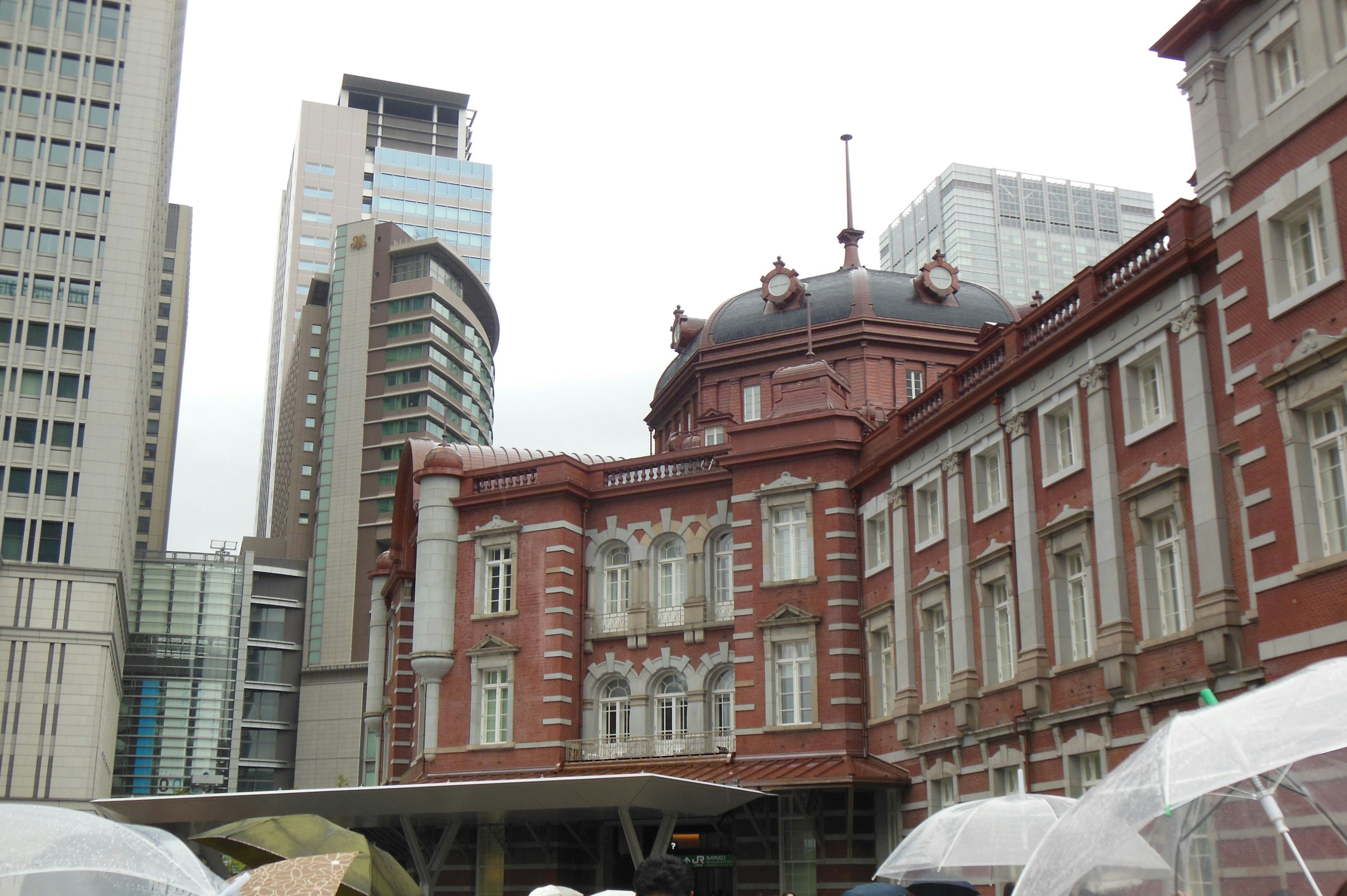 Historic Tokyo Station building with modern skyscrapers in the background