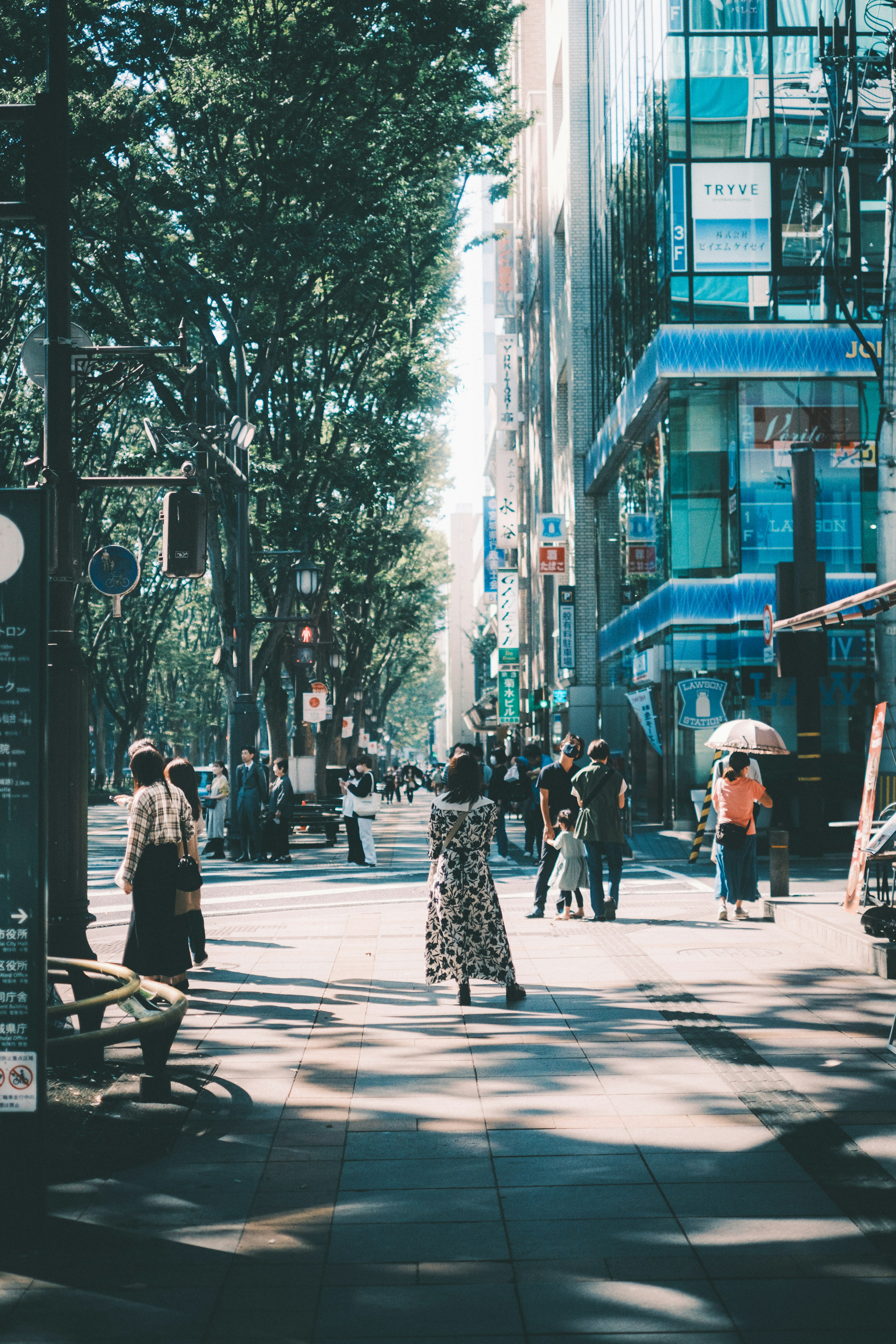 Busy street scene with people walking and blue buildings