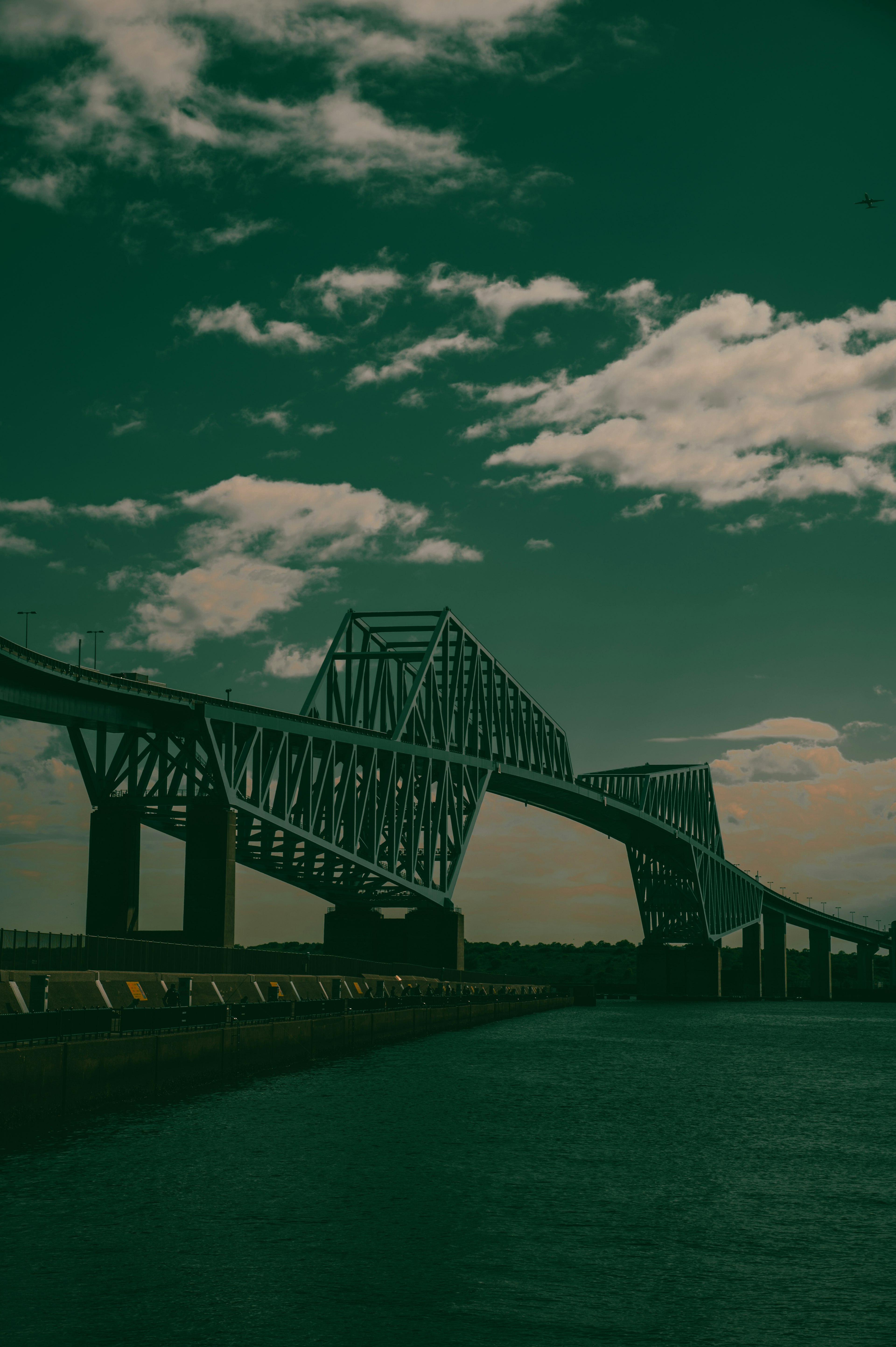 A view of a steel bridge under a green sky