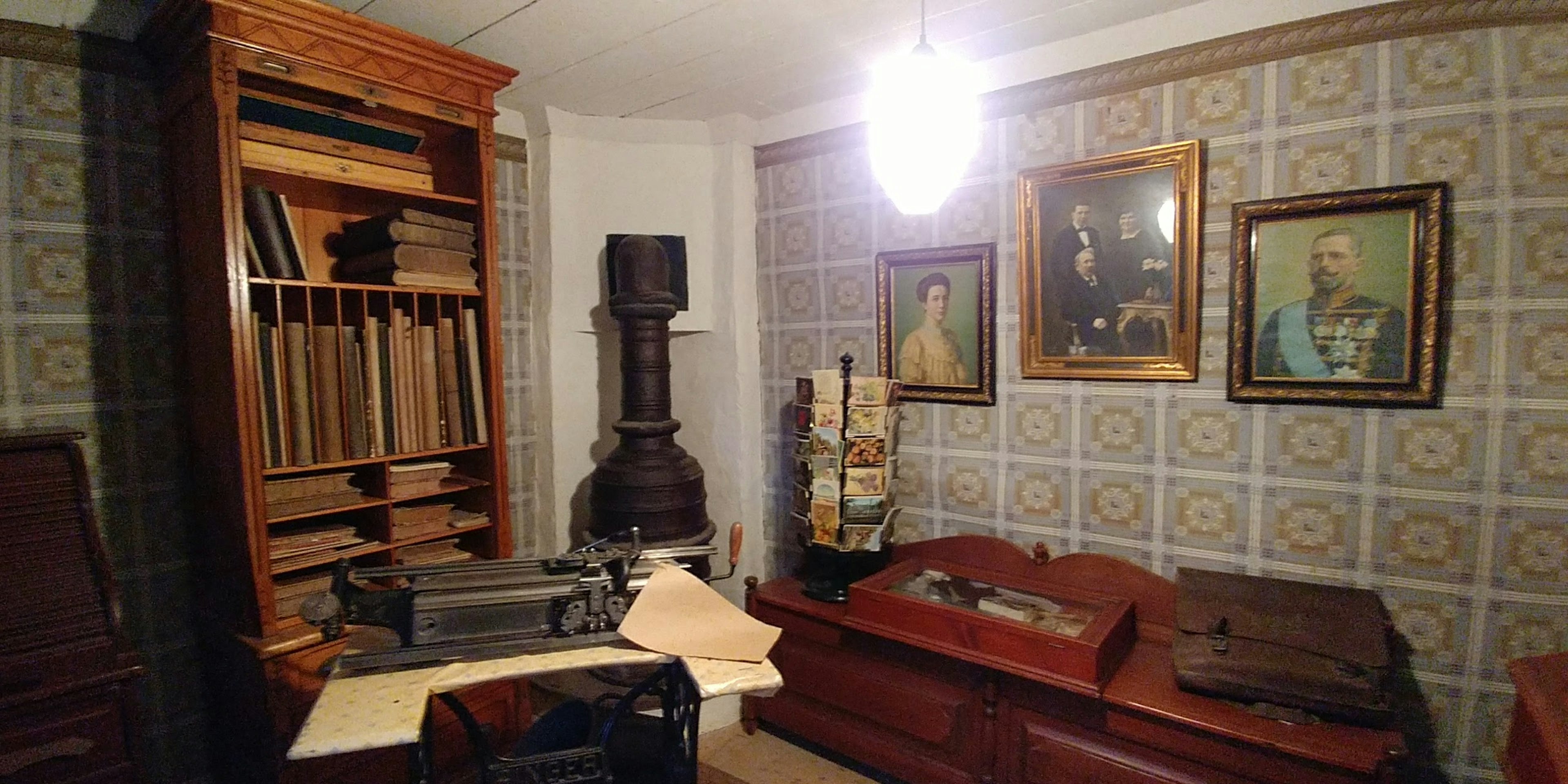 Antique study interior featuring a bookshelf and an old typewriter