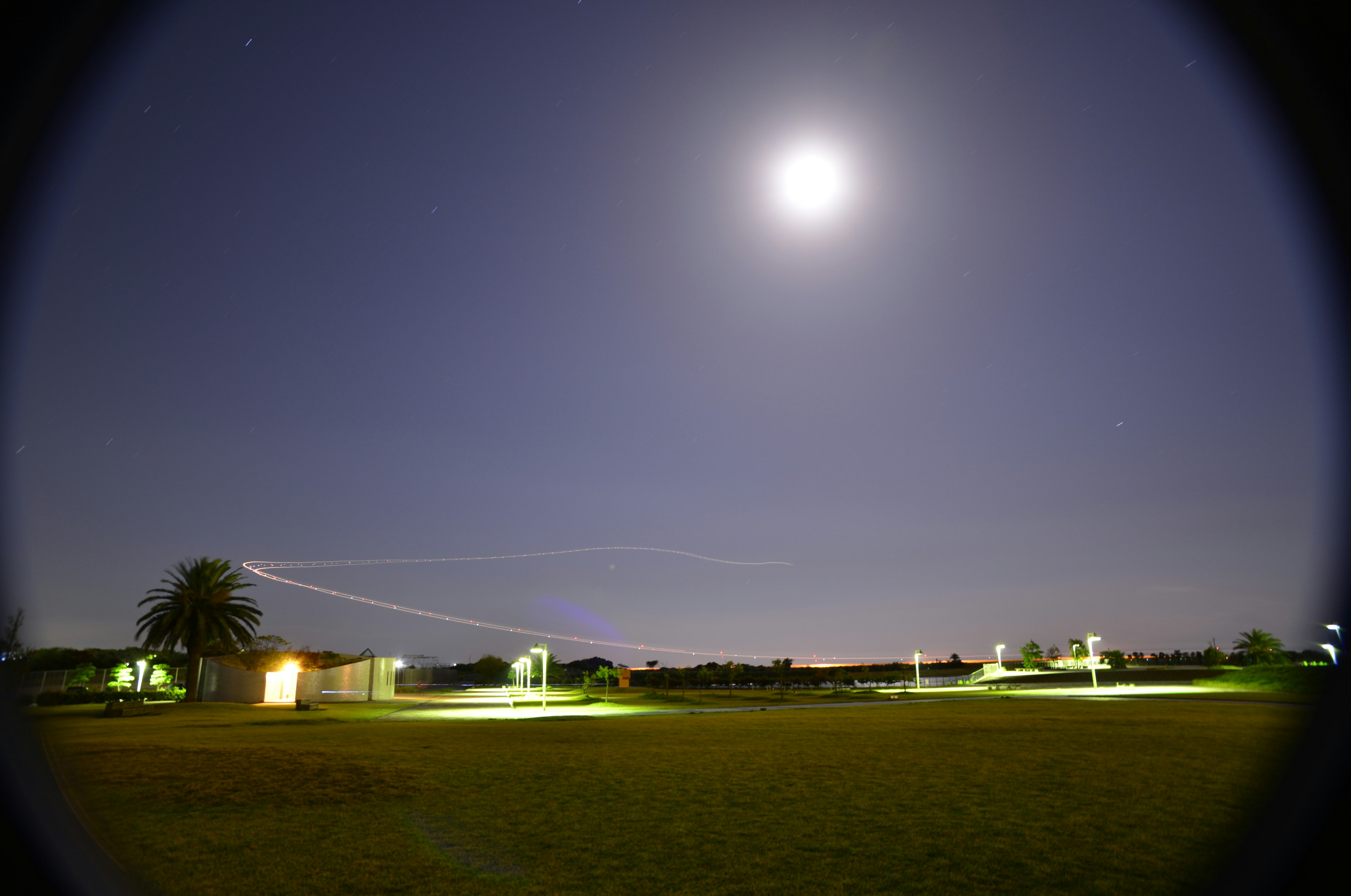 Langit malam dengan bulan purnama yang cerah dan lingkungan yang diterangi