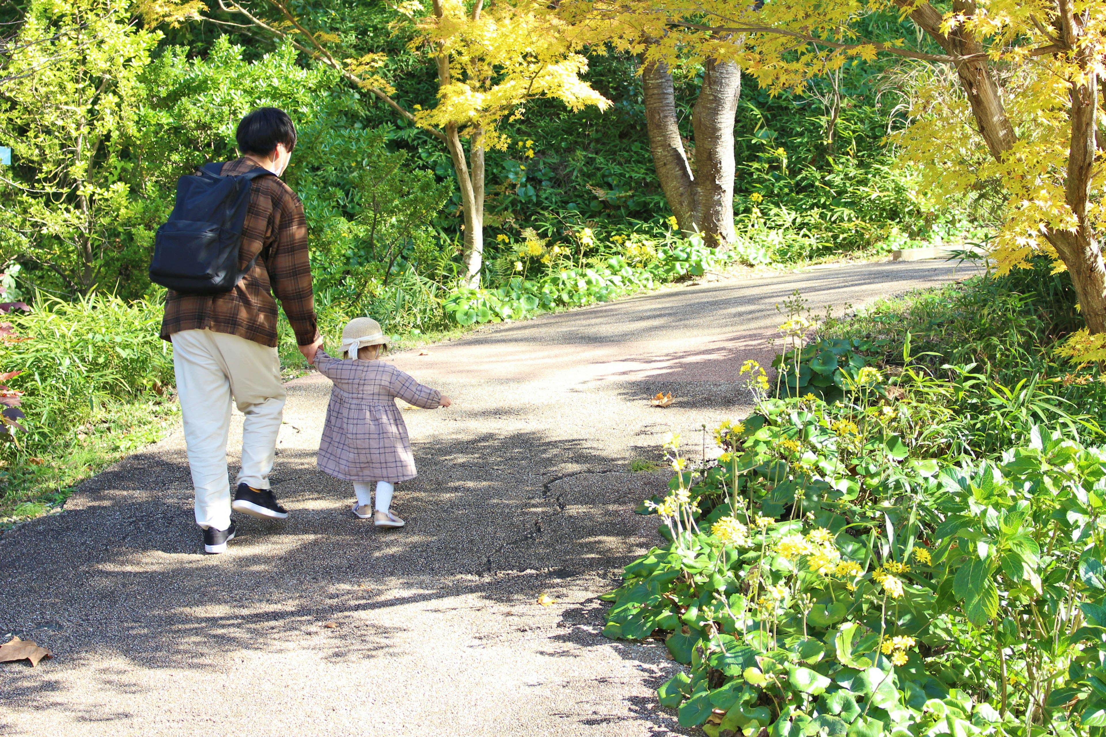 A parent and child walking along an autumn path