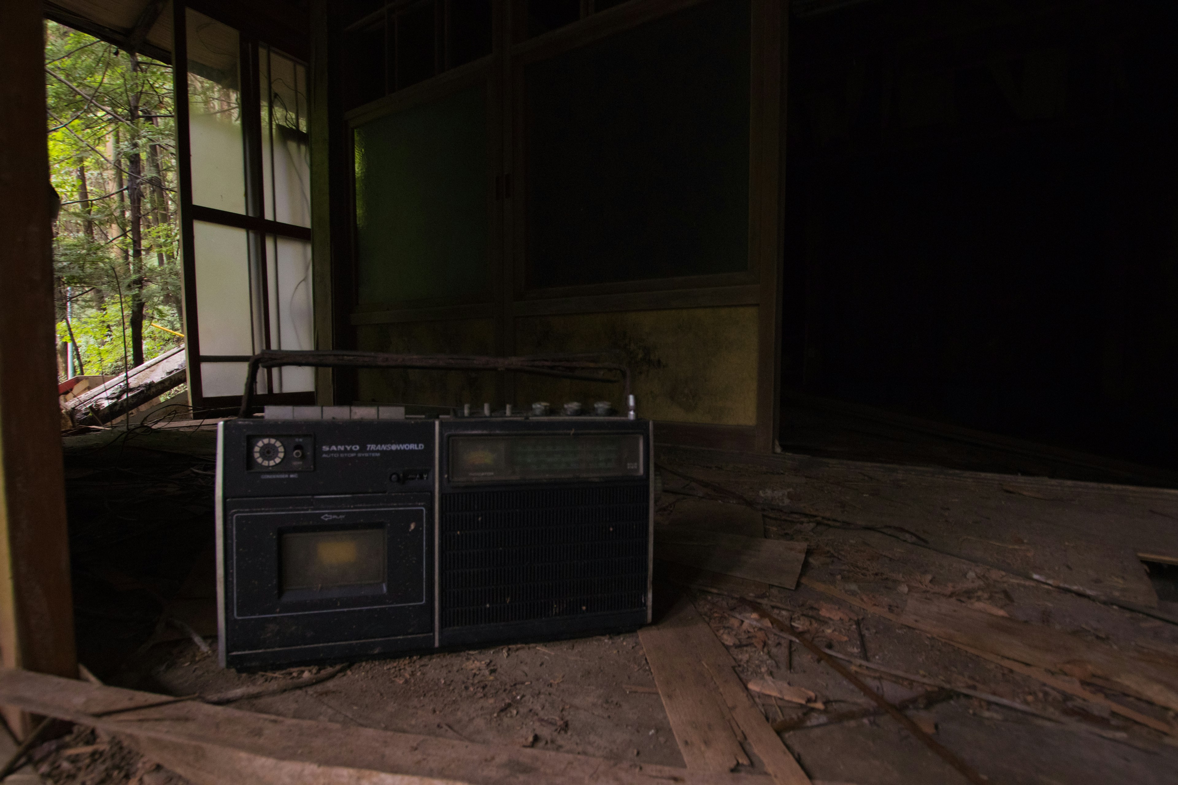 Una radio antigua colocada en el suelo en descomposición de un interior abandonado