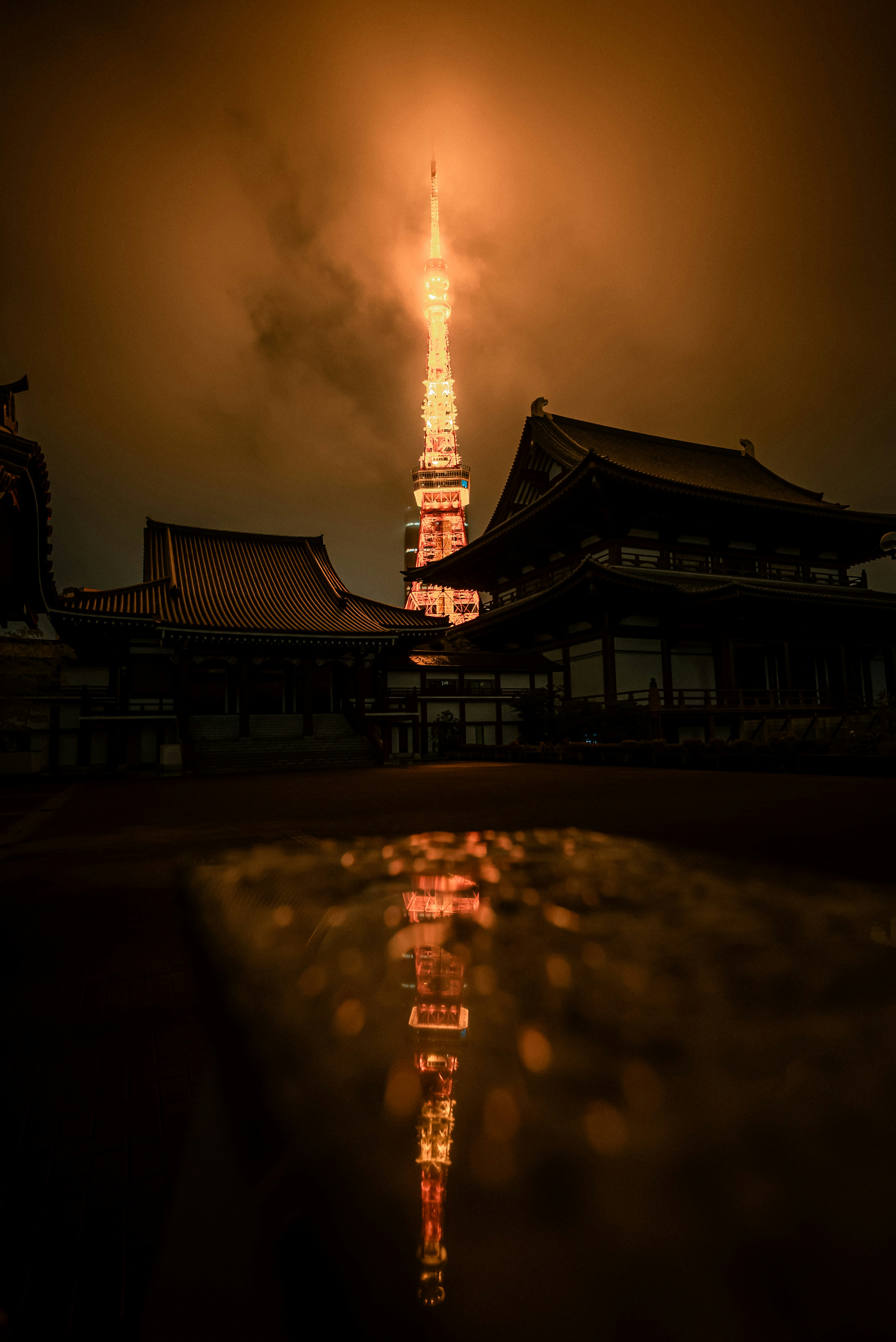 Menara Tokyo diterangi di malam hari dengan refleksi di latar depan