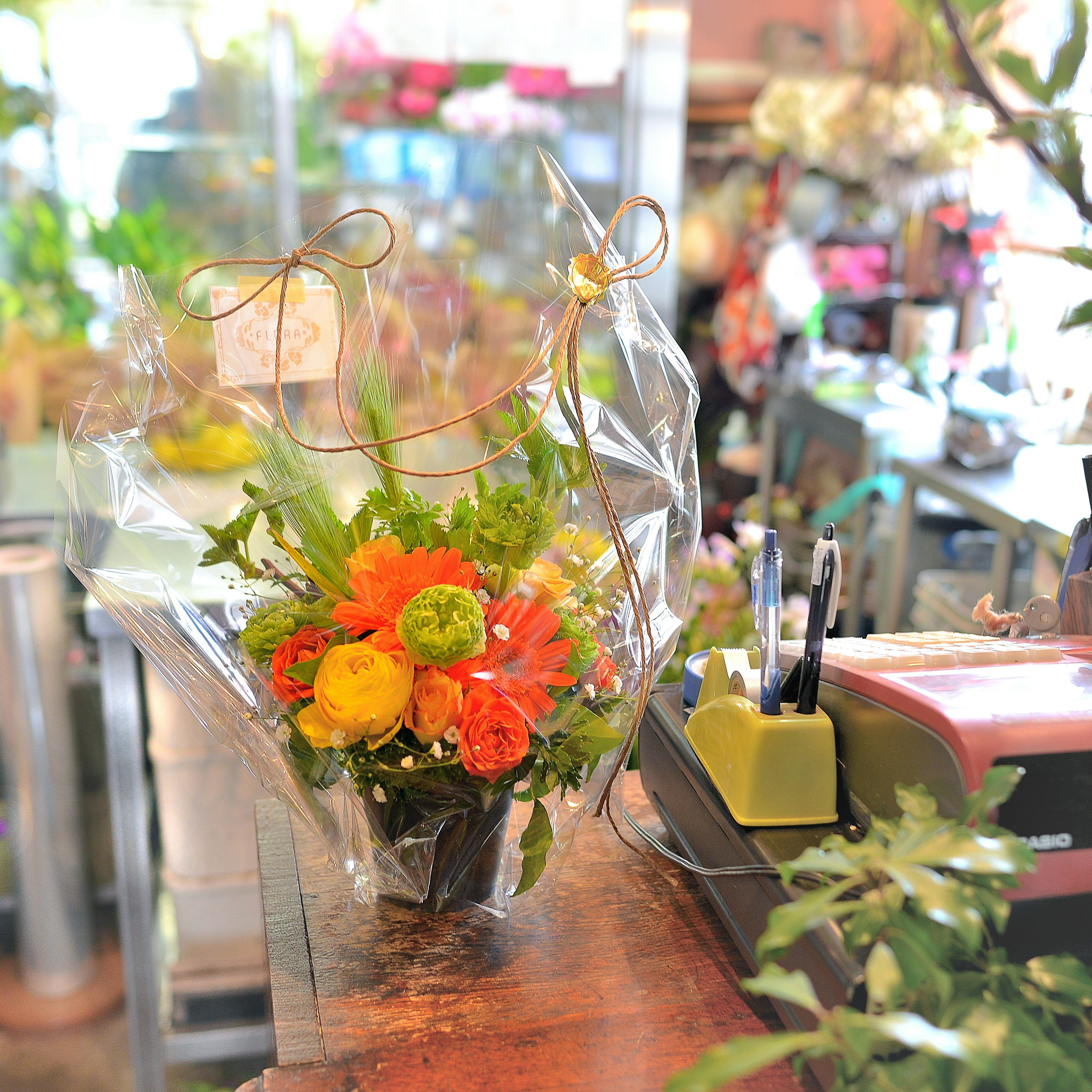 Vibrant bouquet wrapped in clear plastic placed on a counter