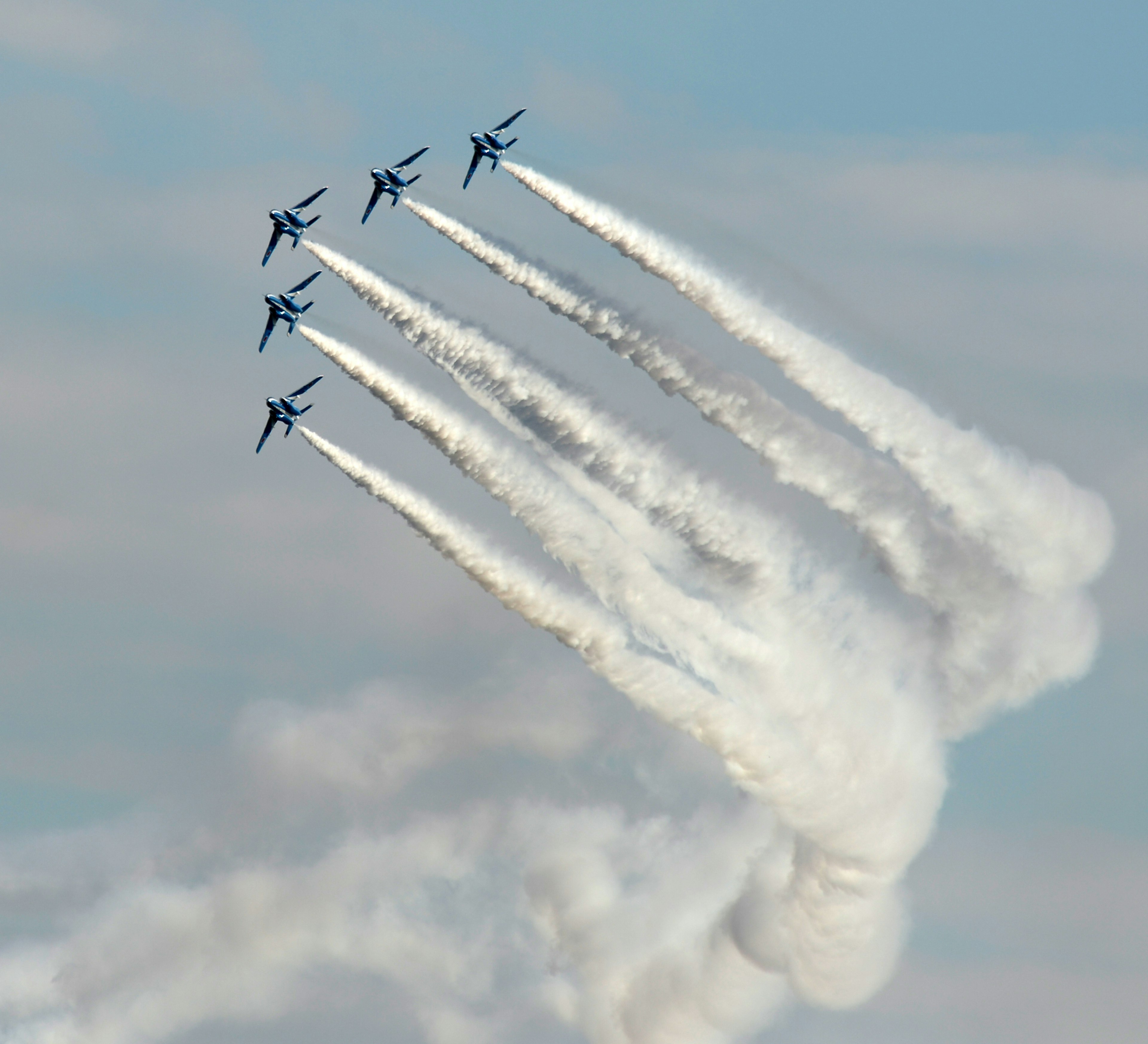 Six avions de chasse s'élevant vers le ciel bleu laissant des traînées de fumée