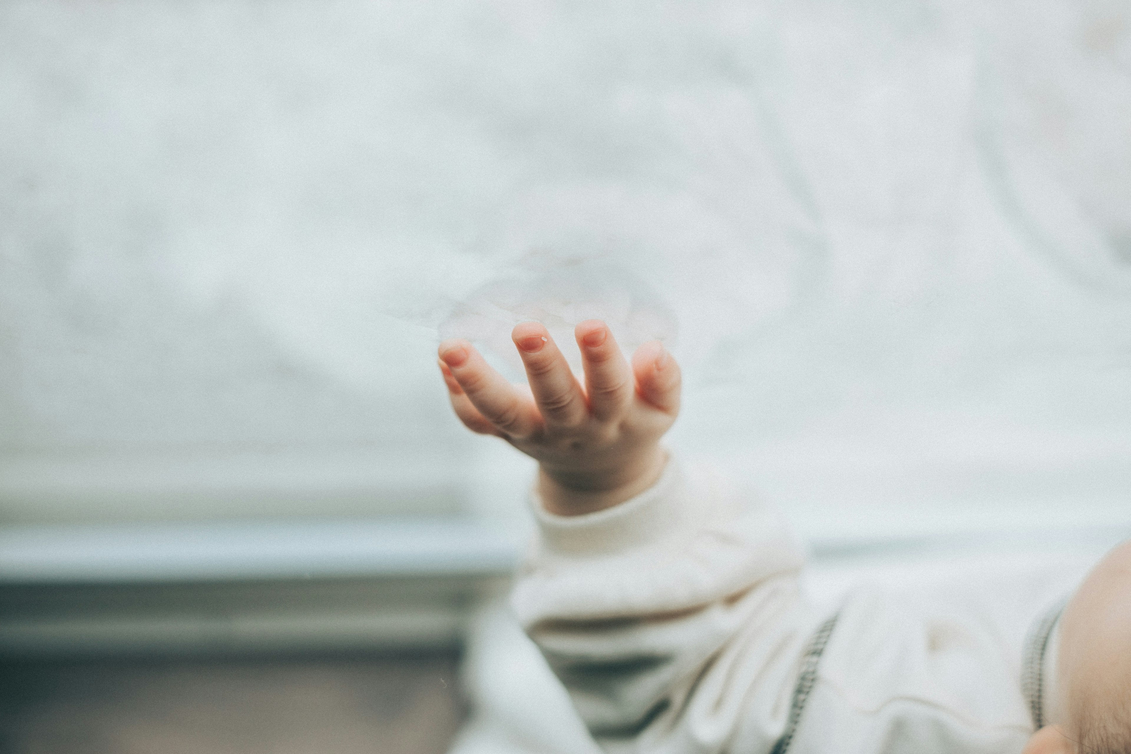 La mano di un bambino che cerca di afferrare una bolla di sapone