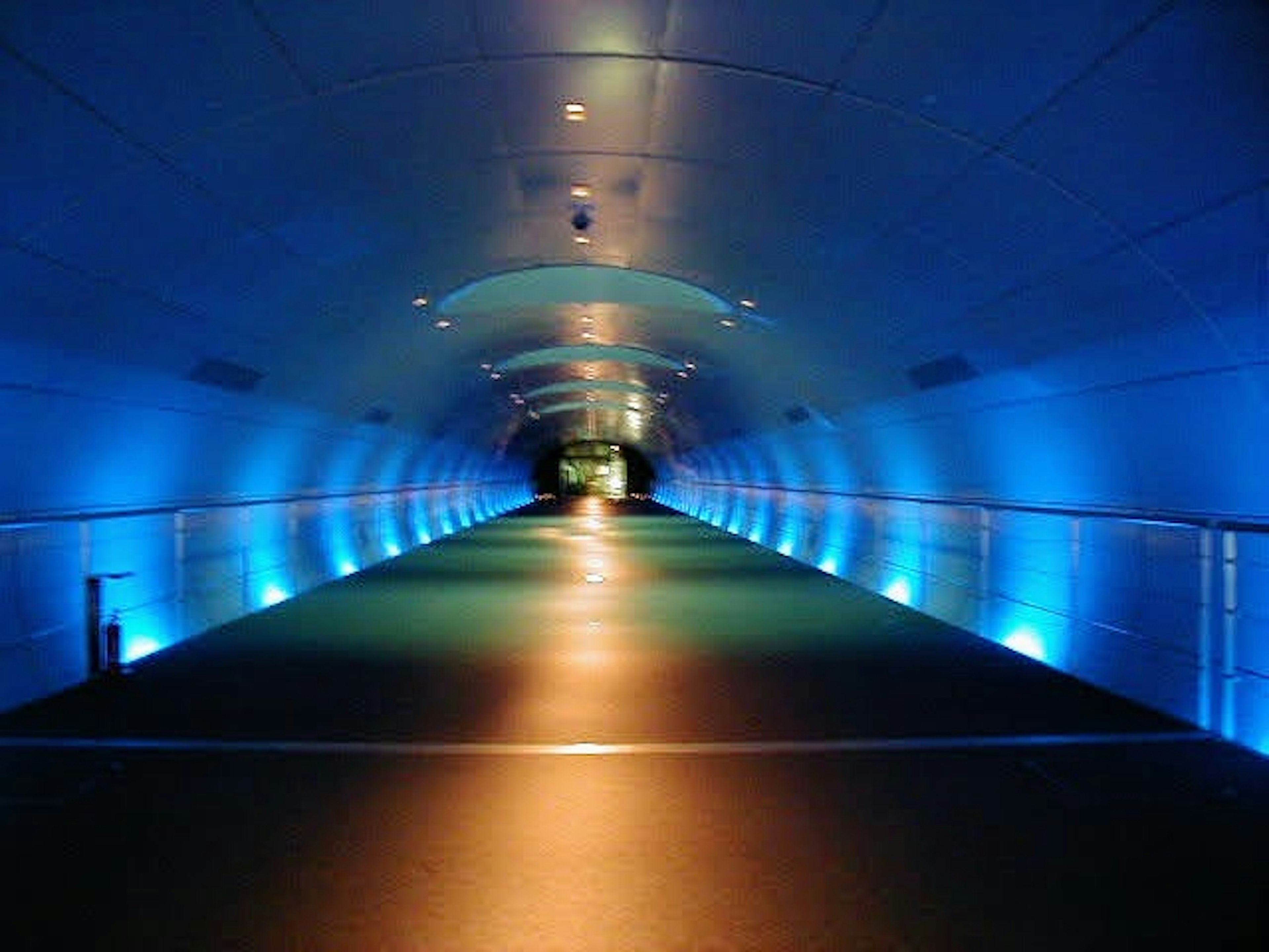 Interno di un lungo tunnel illuminato da luci blu