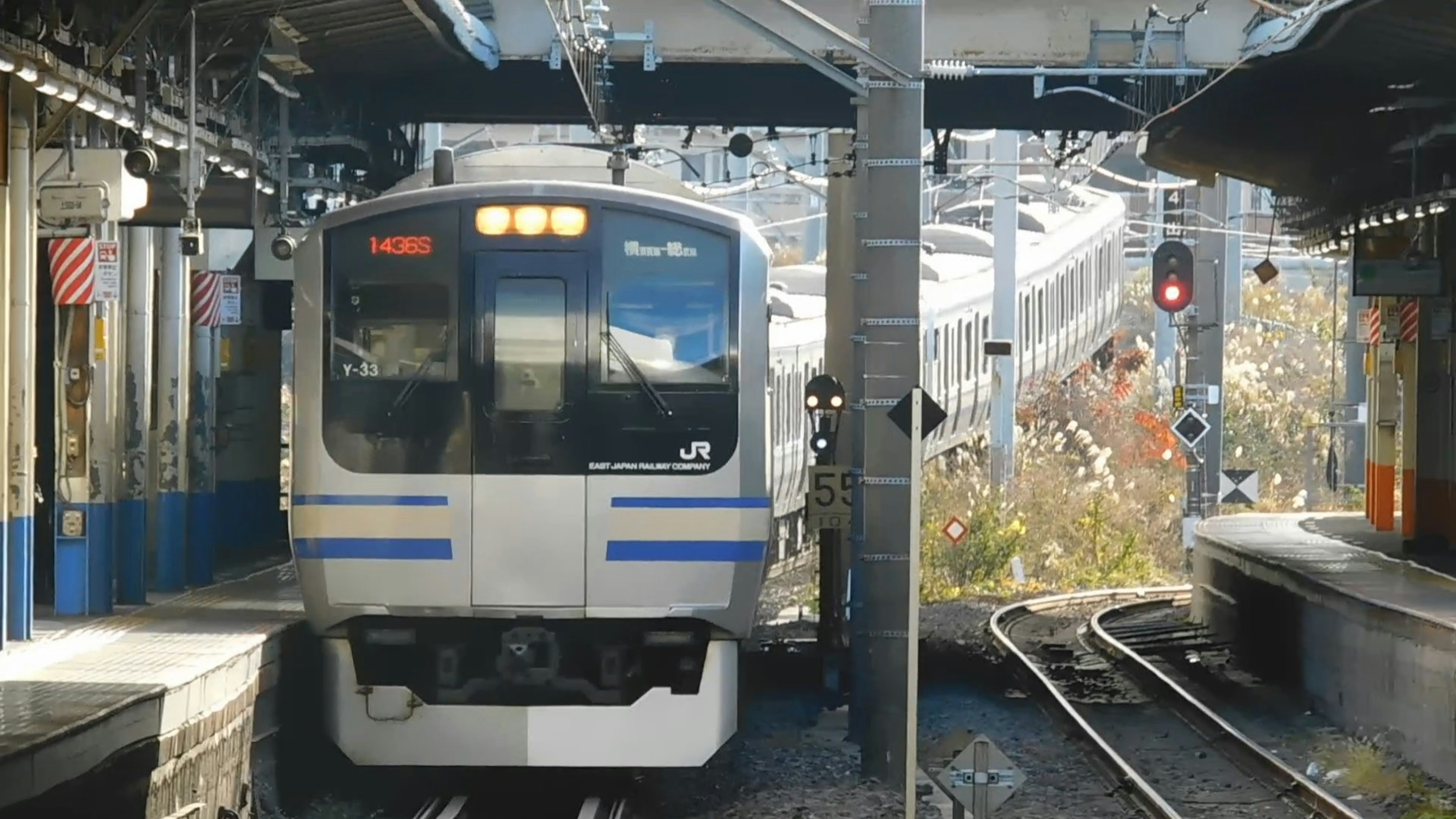 A blue striped train arriving at a station