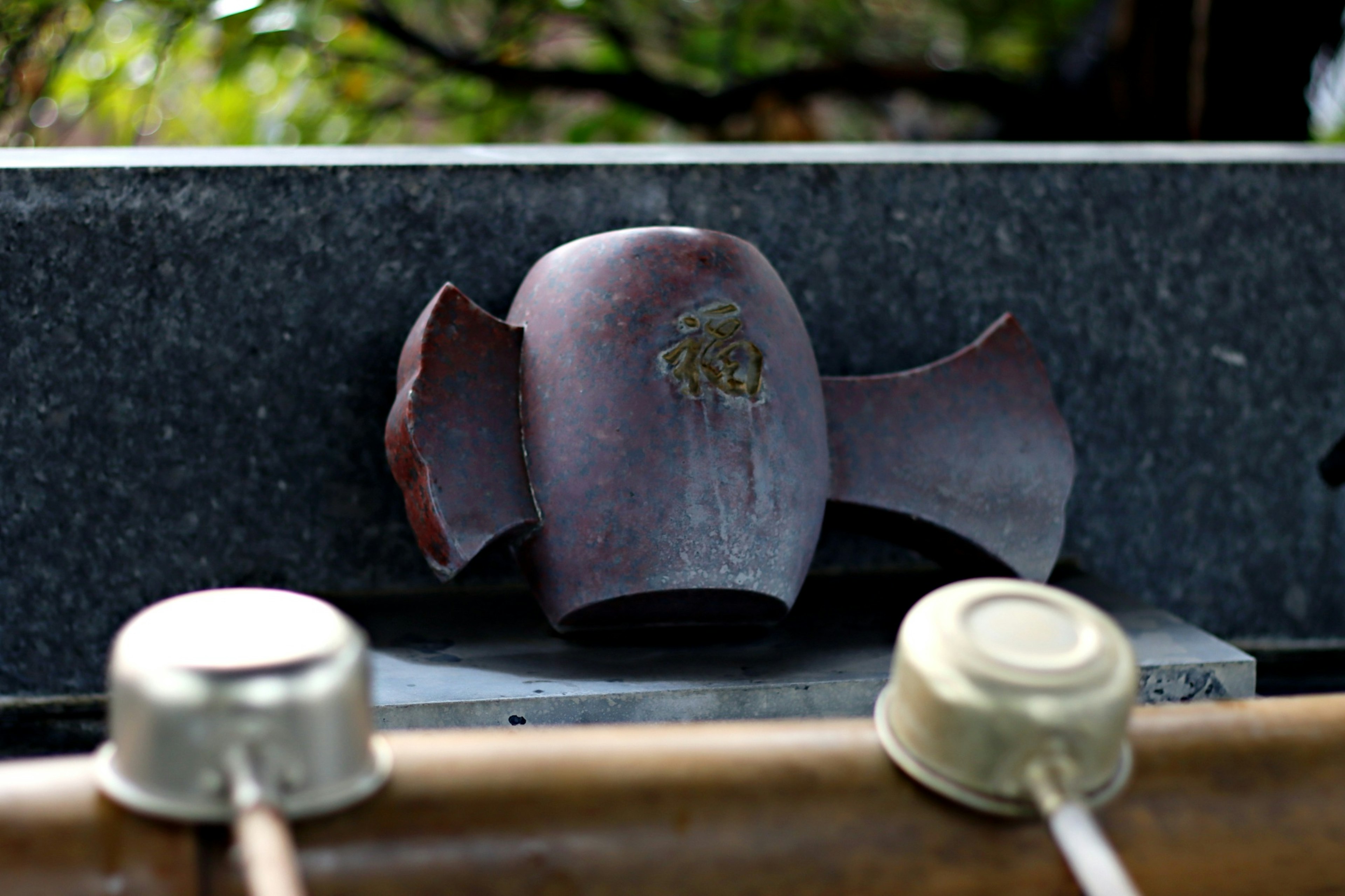 Una estatua de cerámica rota colocada sobre un fondo de piedra