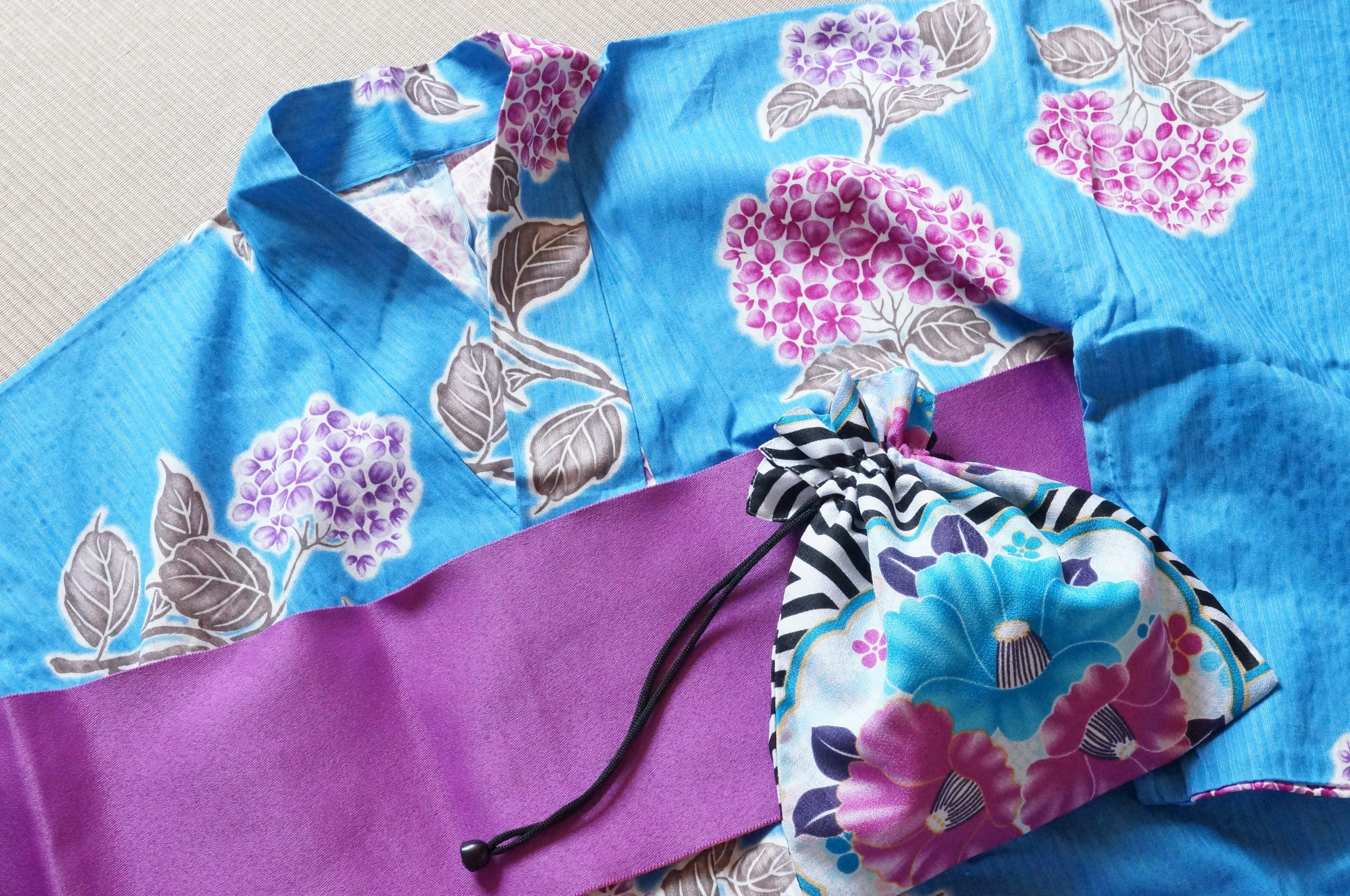 Blue floral kimono with a purple obi and a colorful pouch