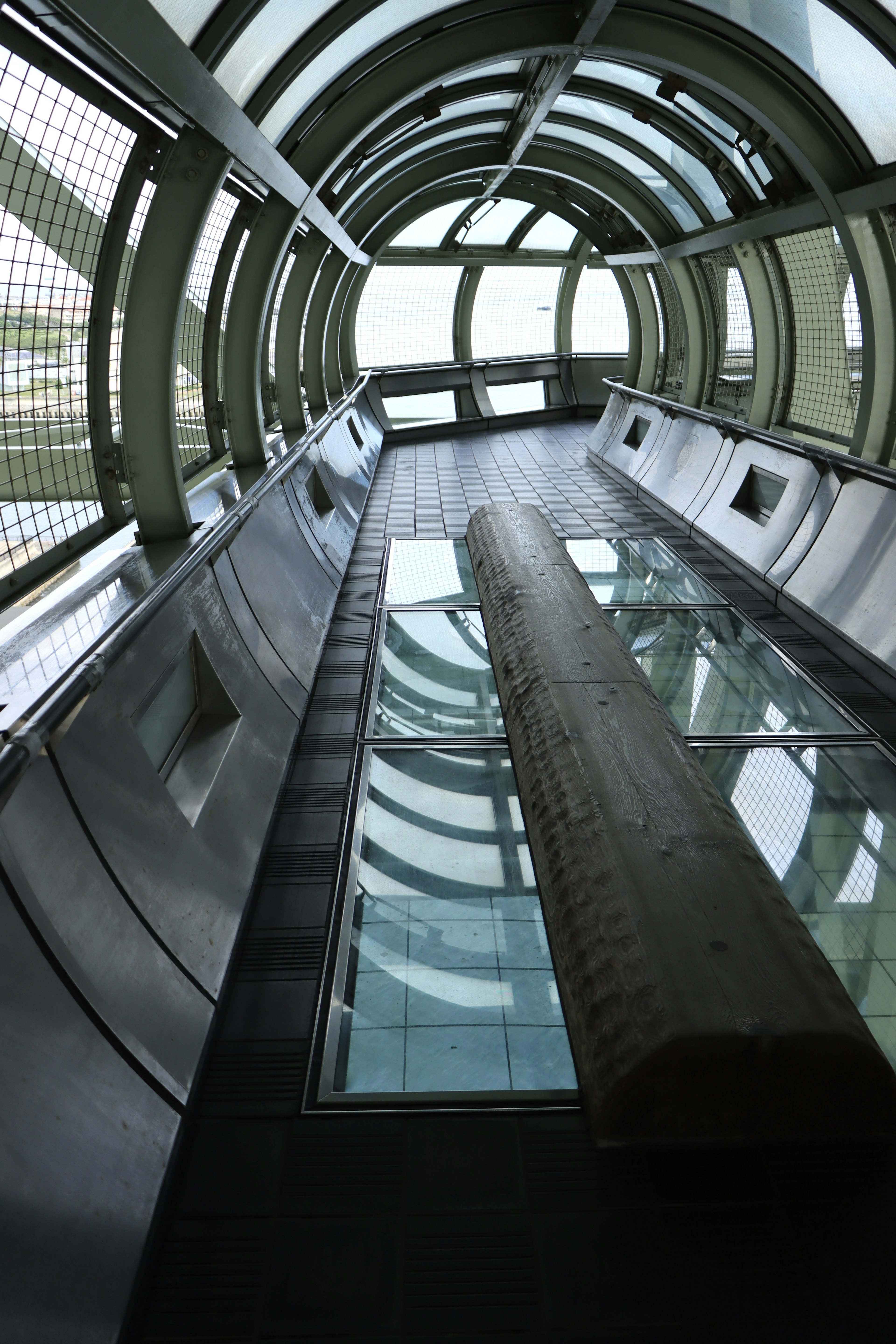 Blick von innen auf ein modernes Gebäude mit Glasboden und kreisförmiger Architektur