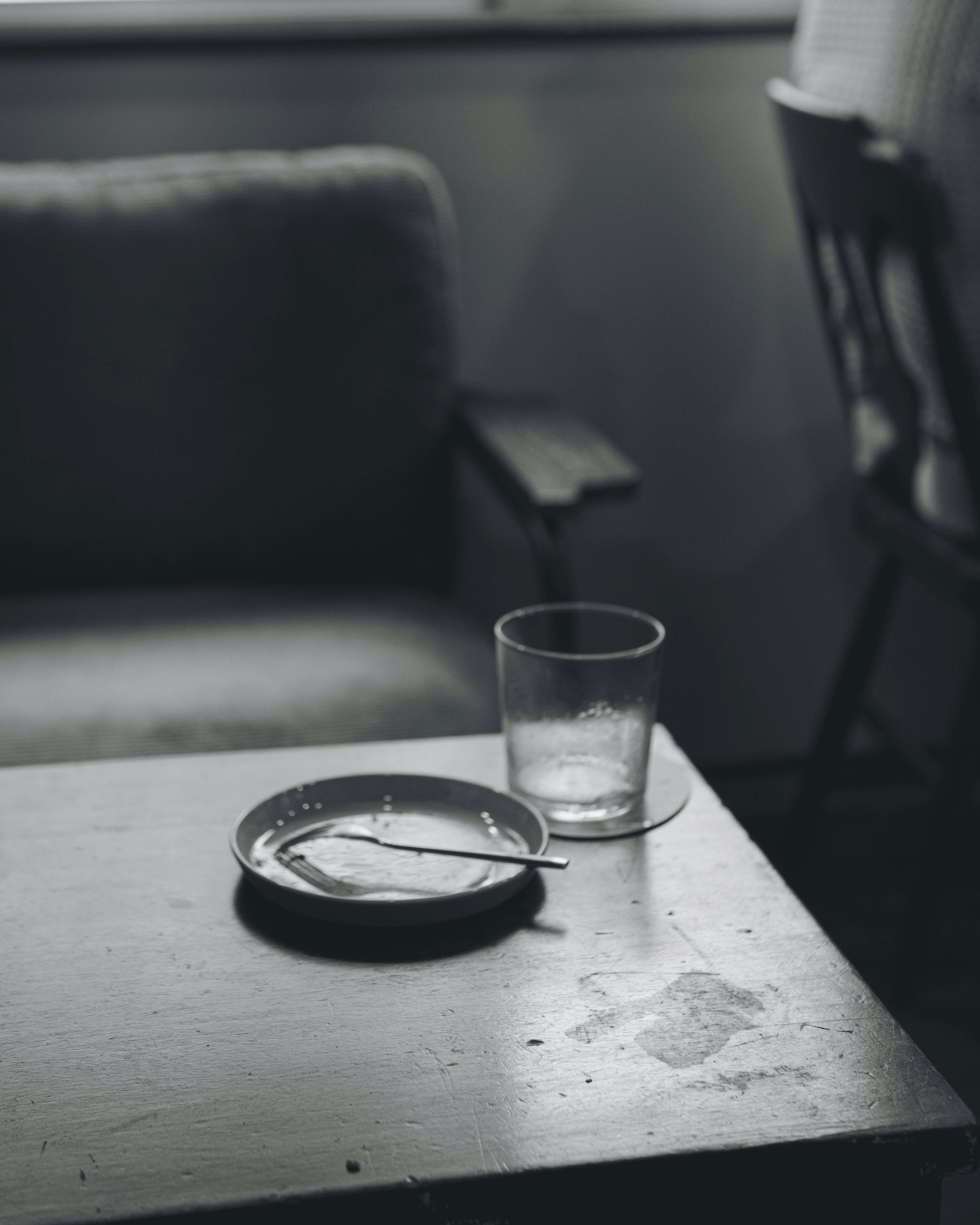 Foto still life hitam putih dengan asbak dan gelas di atas meja