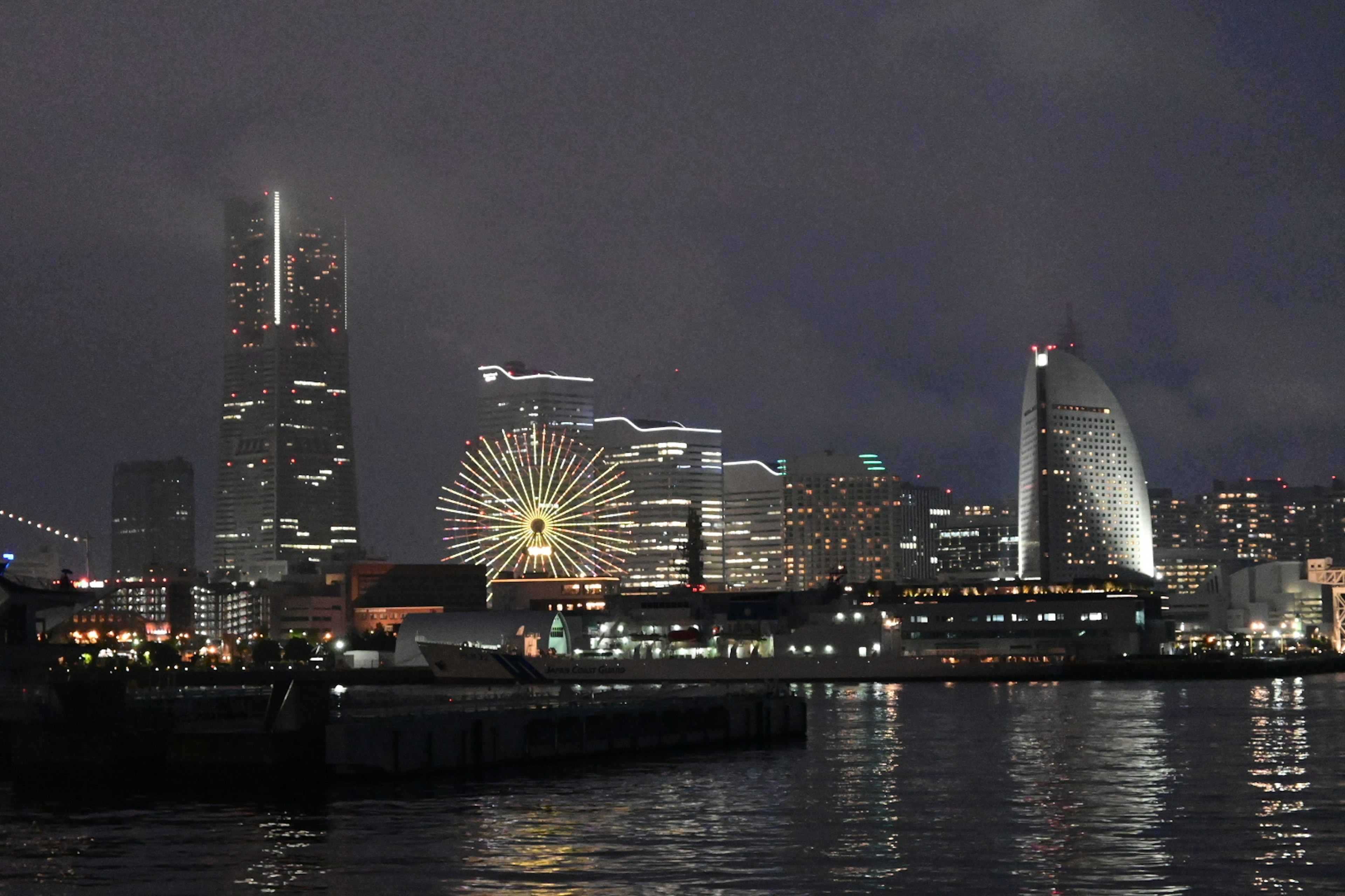 Vista notturna dello skyline di Yokohama con la Landmark Tower e la ruota panoramica