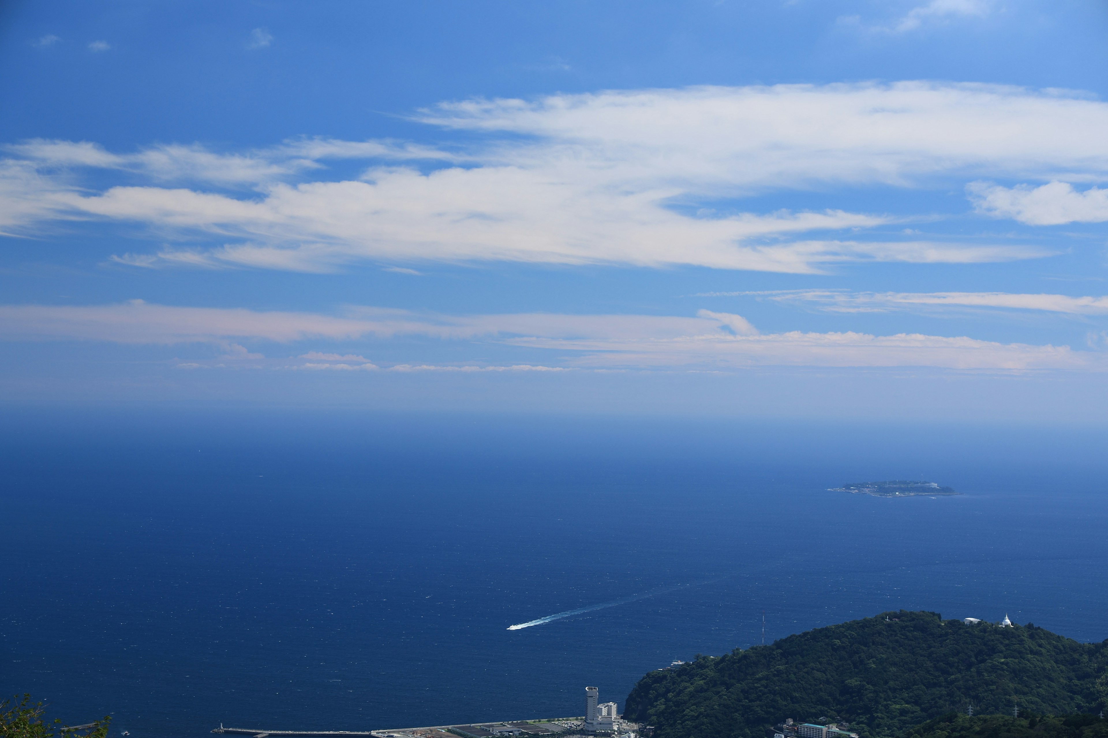 Un vasto mare blu e cielo con un'isola in lontananza