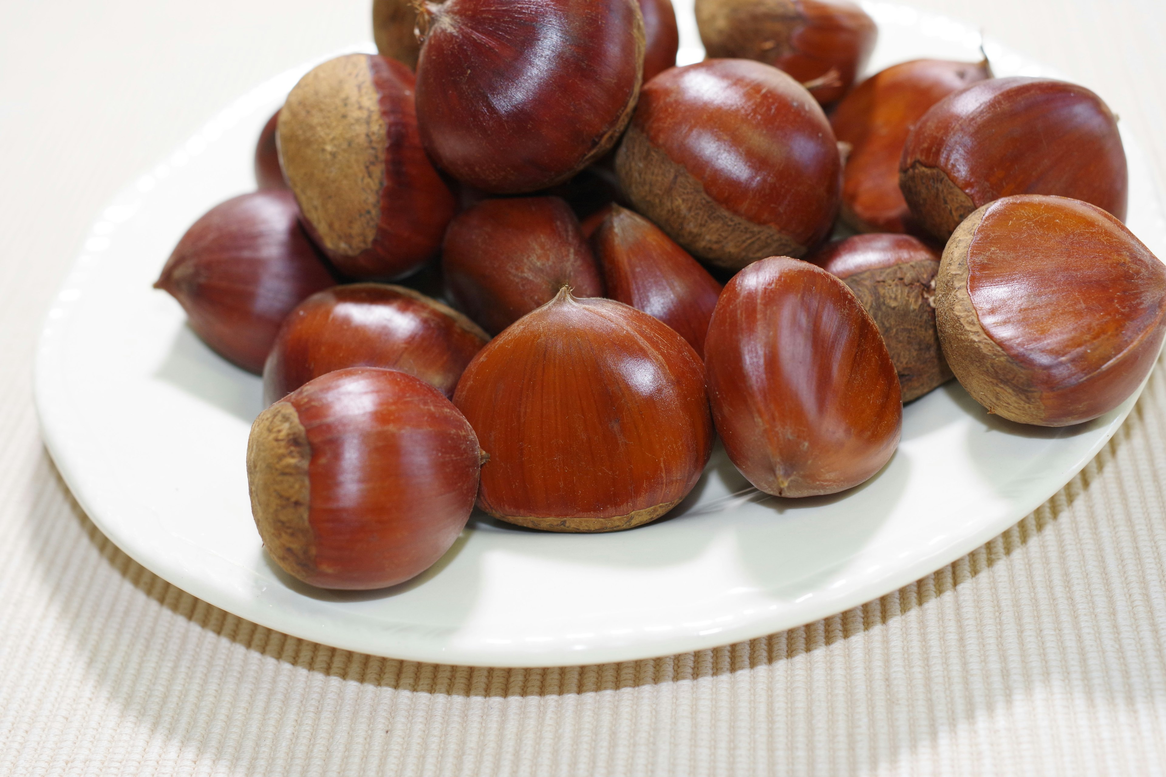 A plate filled with shiny brown chestnuts