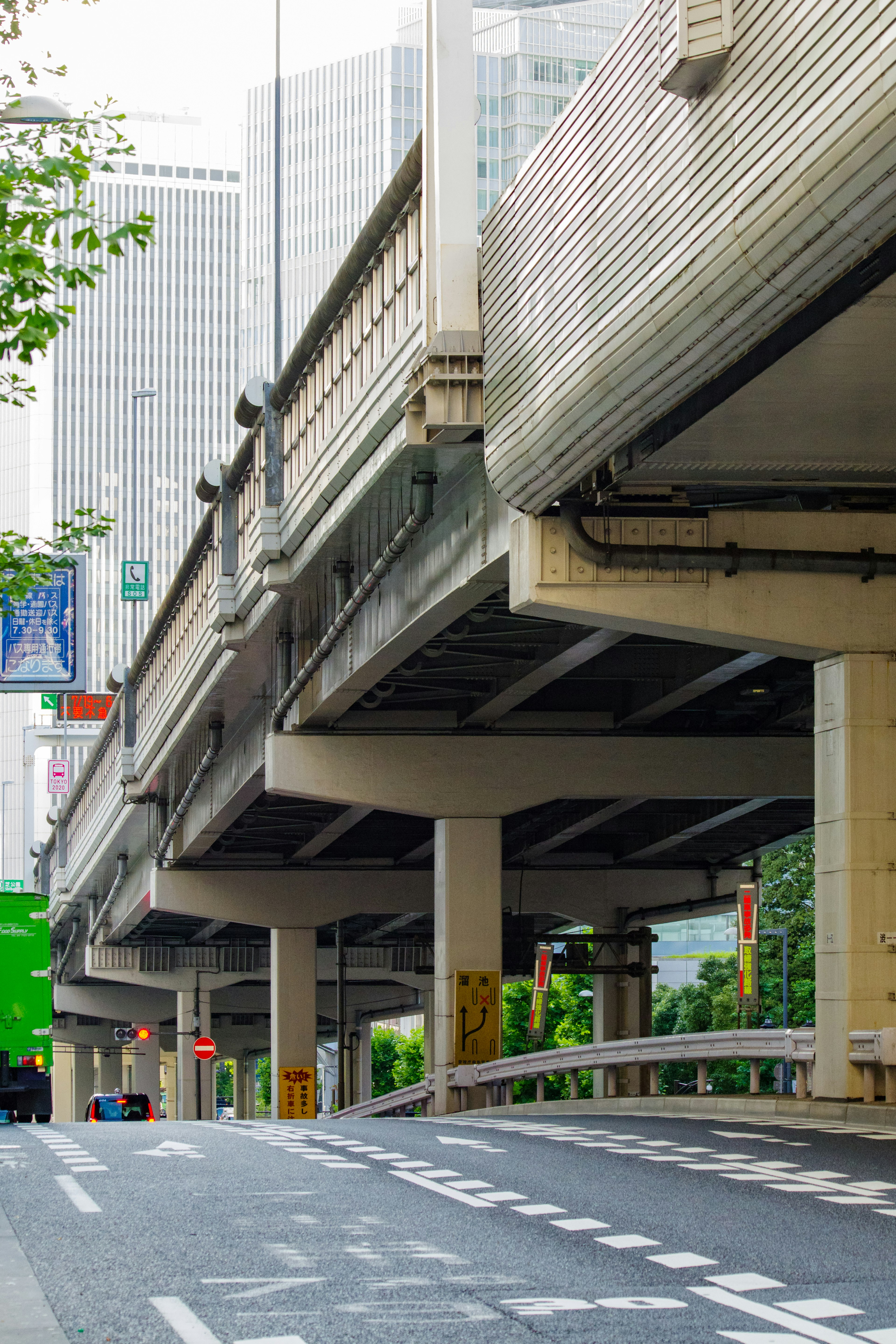 Pemandangan perkotaan dengan jembatan layang dan pohon hijau di dekatnya