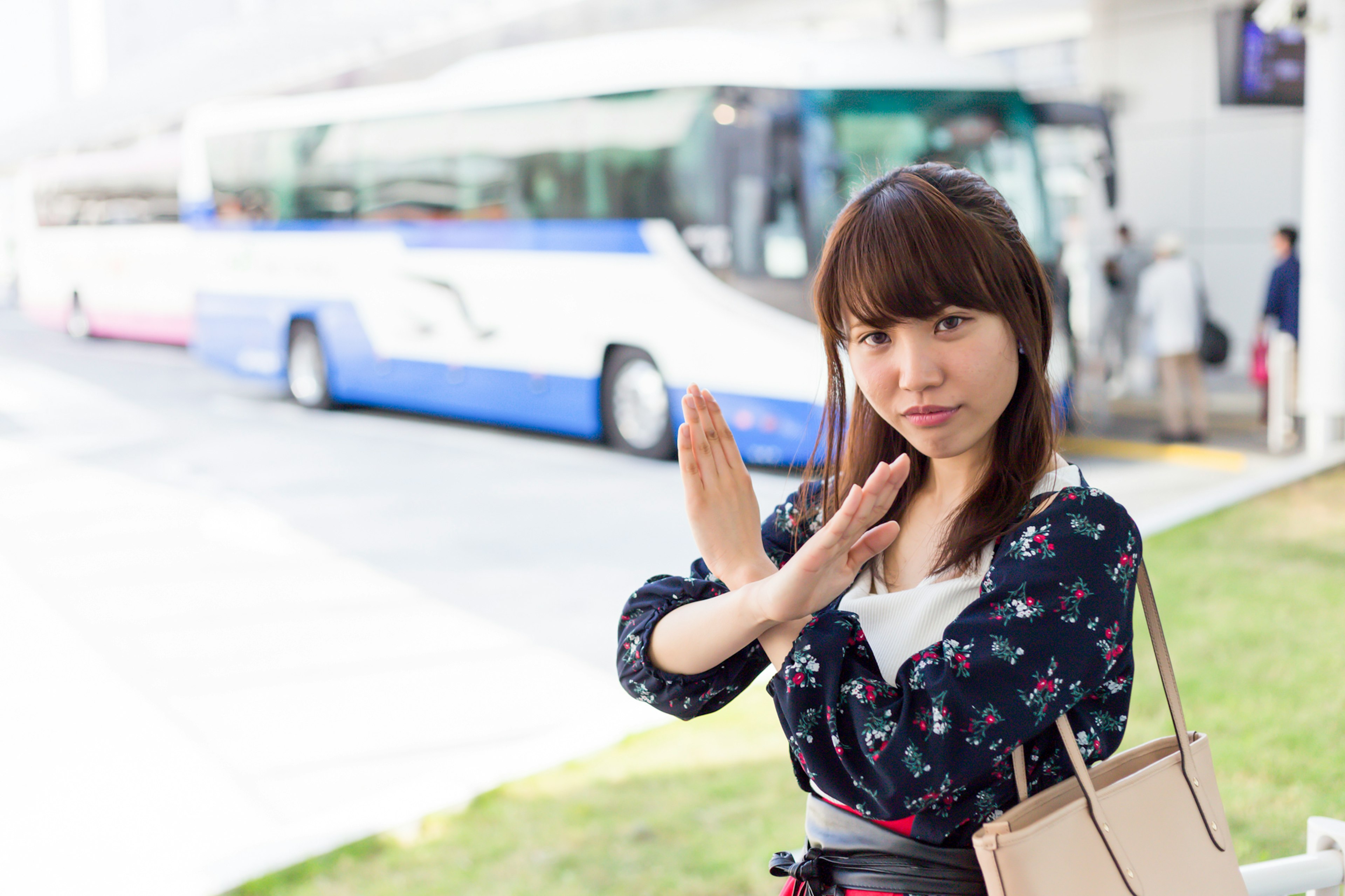 A woman posing in front of a bus