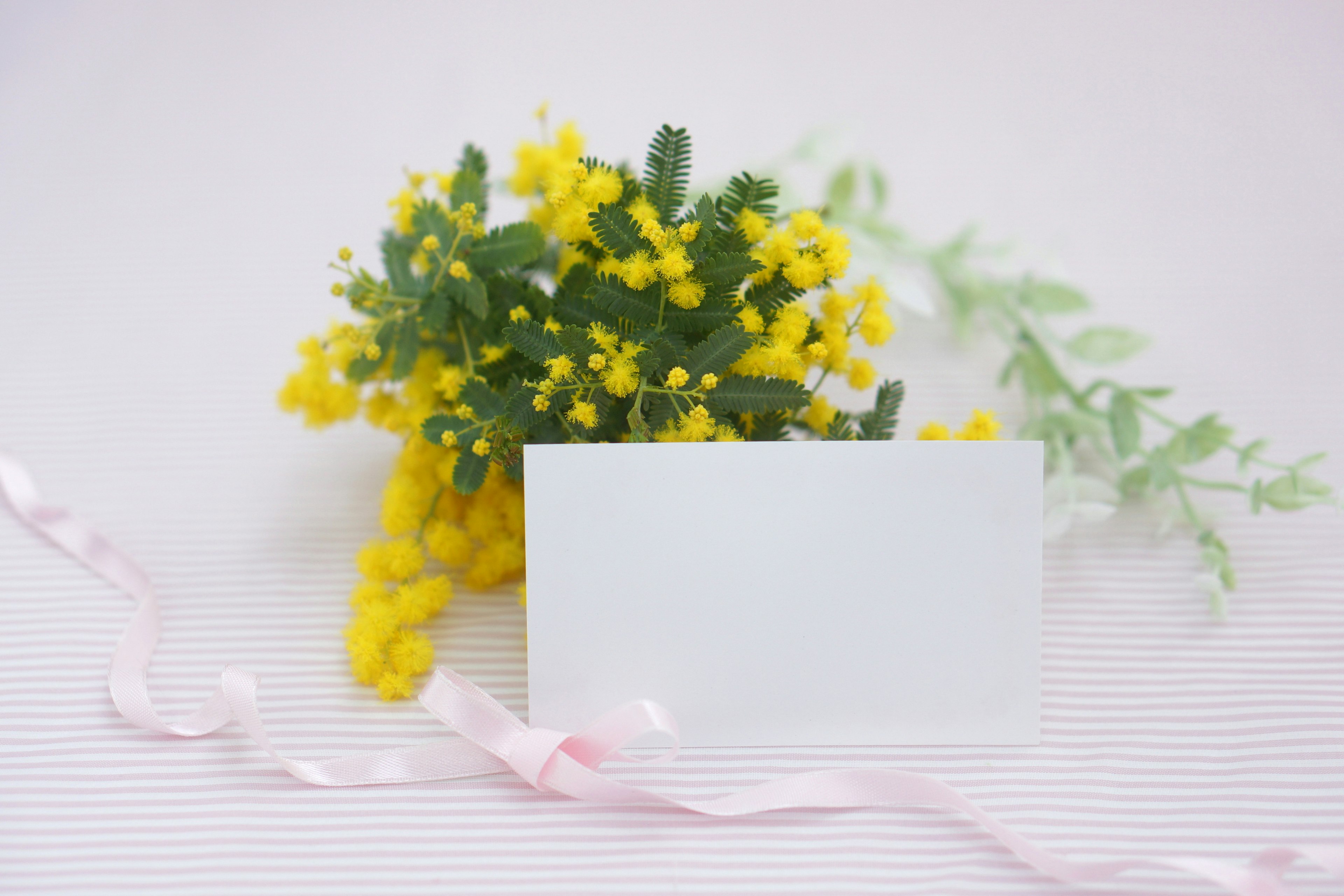 Un arrangement simple et beau avec des fleurs jaunes et une carte blanche