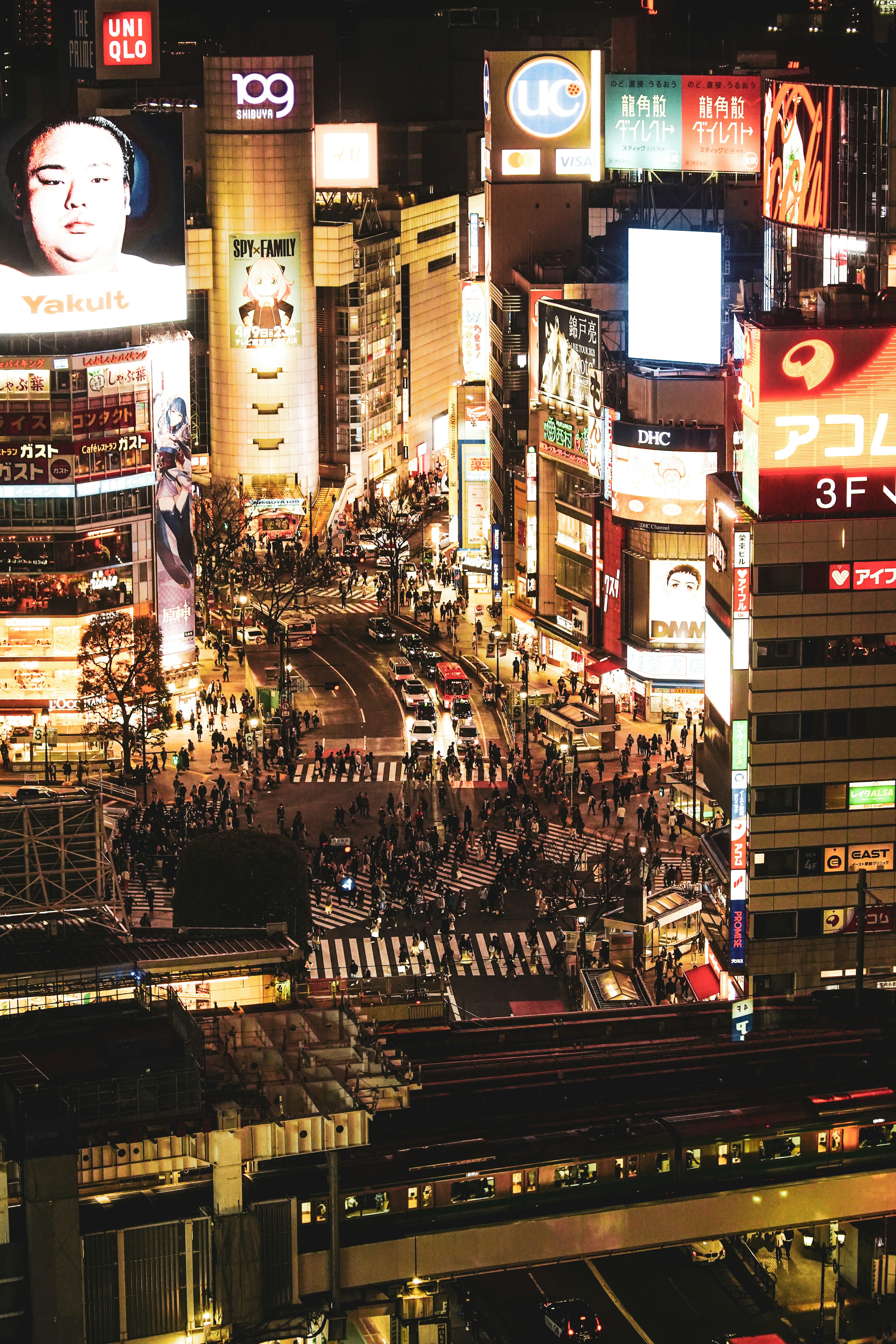 Cruce de Shibuya concurrido de noche con luces brillantes y multitudes