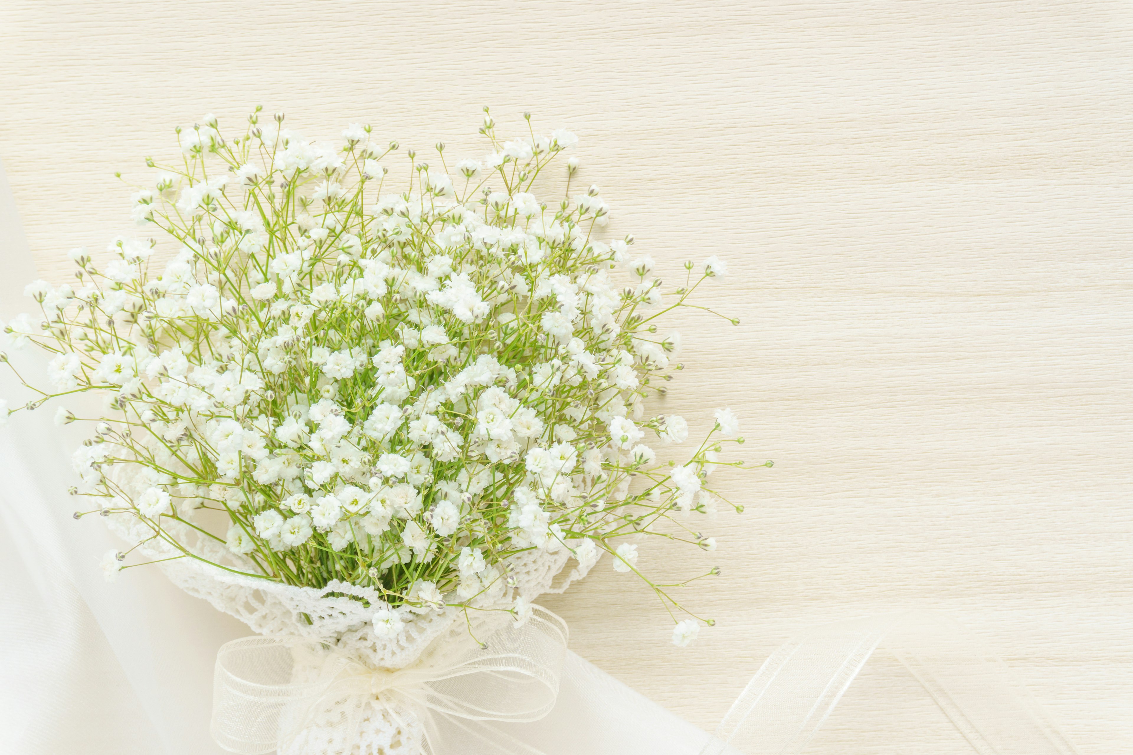 A bouquet of small white flowers wrapped with a ribbon