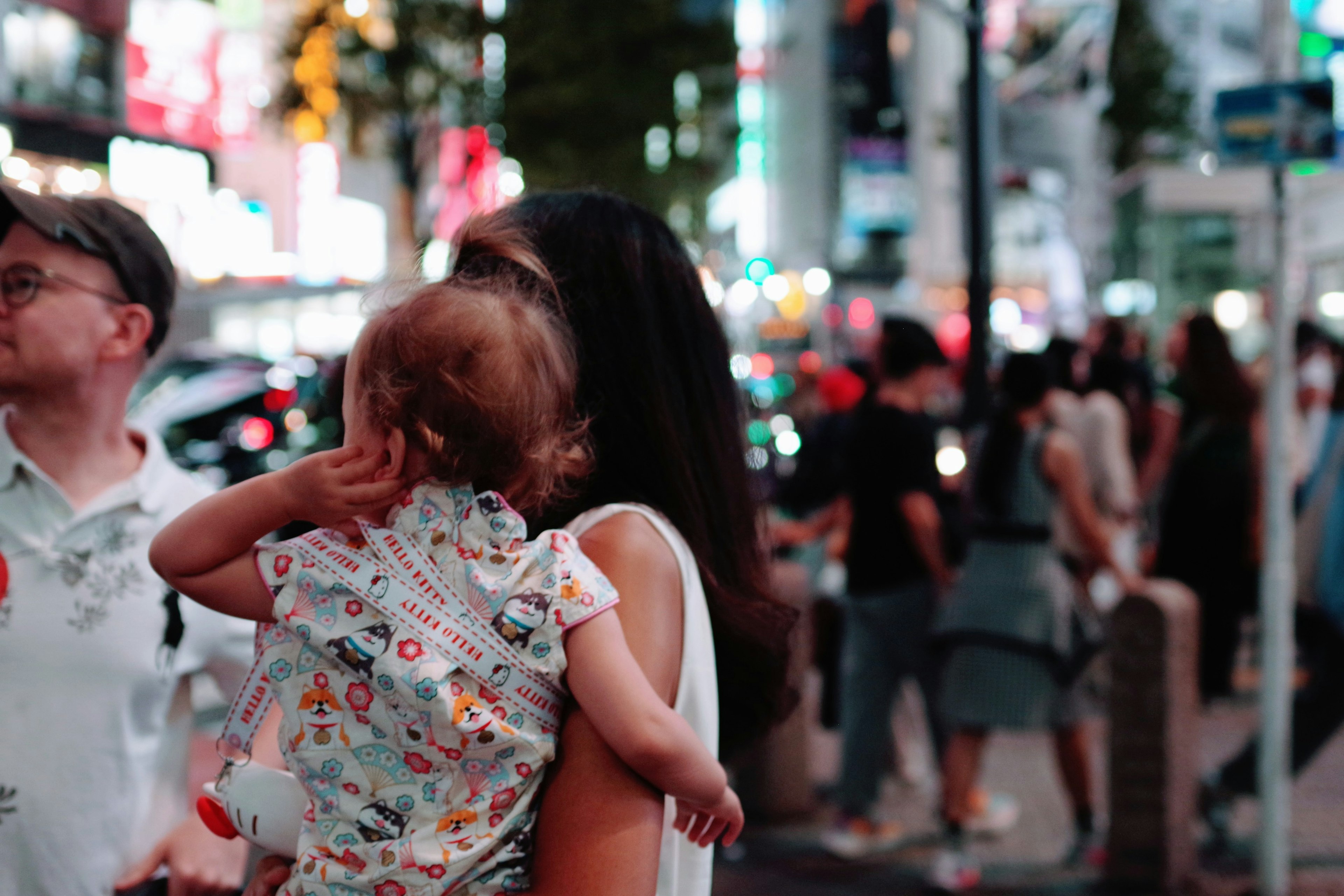 夜の街を背景に子供を抱く女性の後ろ姿