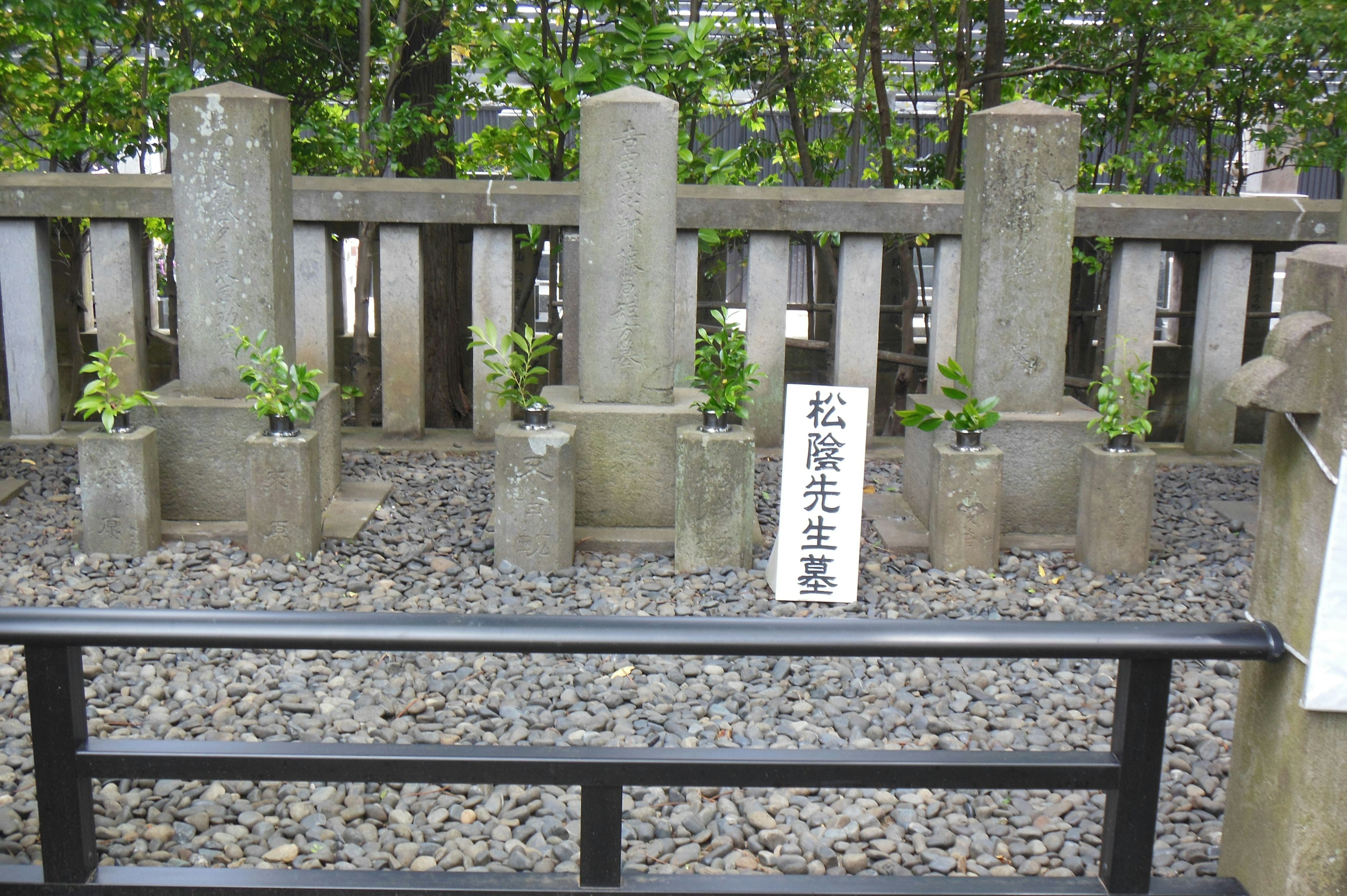 A serene cemetery scene featuring stone monuments and greenery