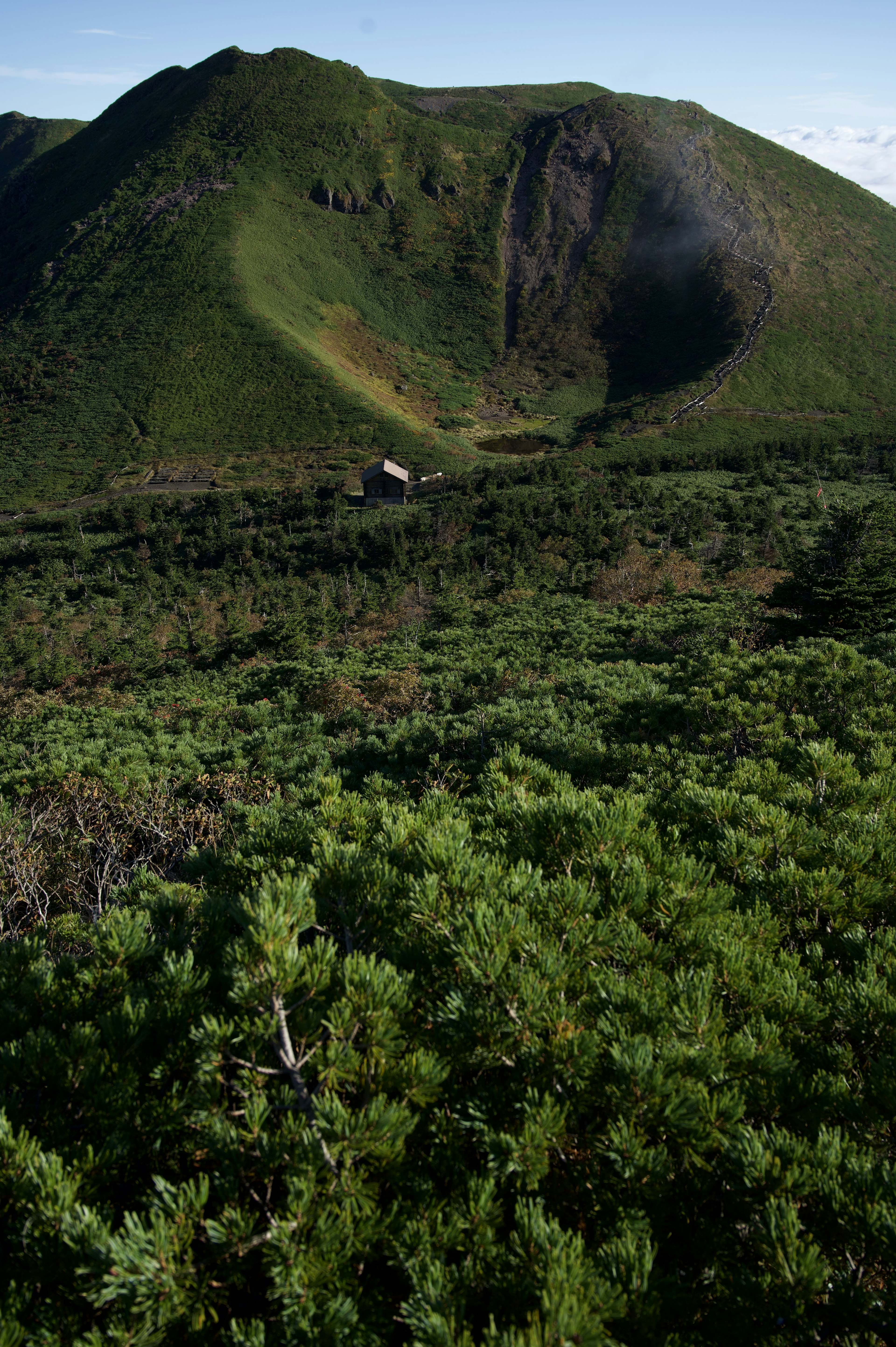 緑豊かな山々と谷間の風景小屋が見える