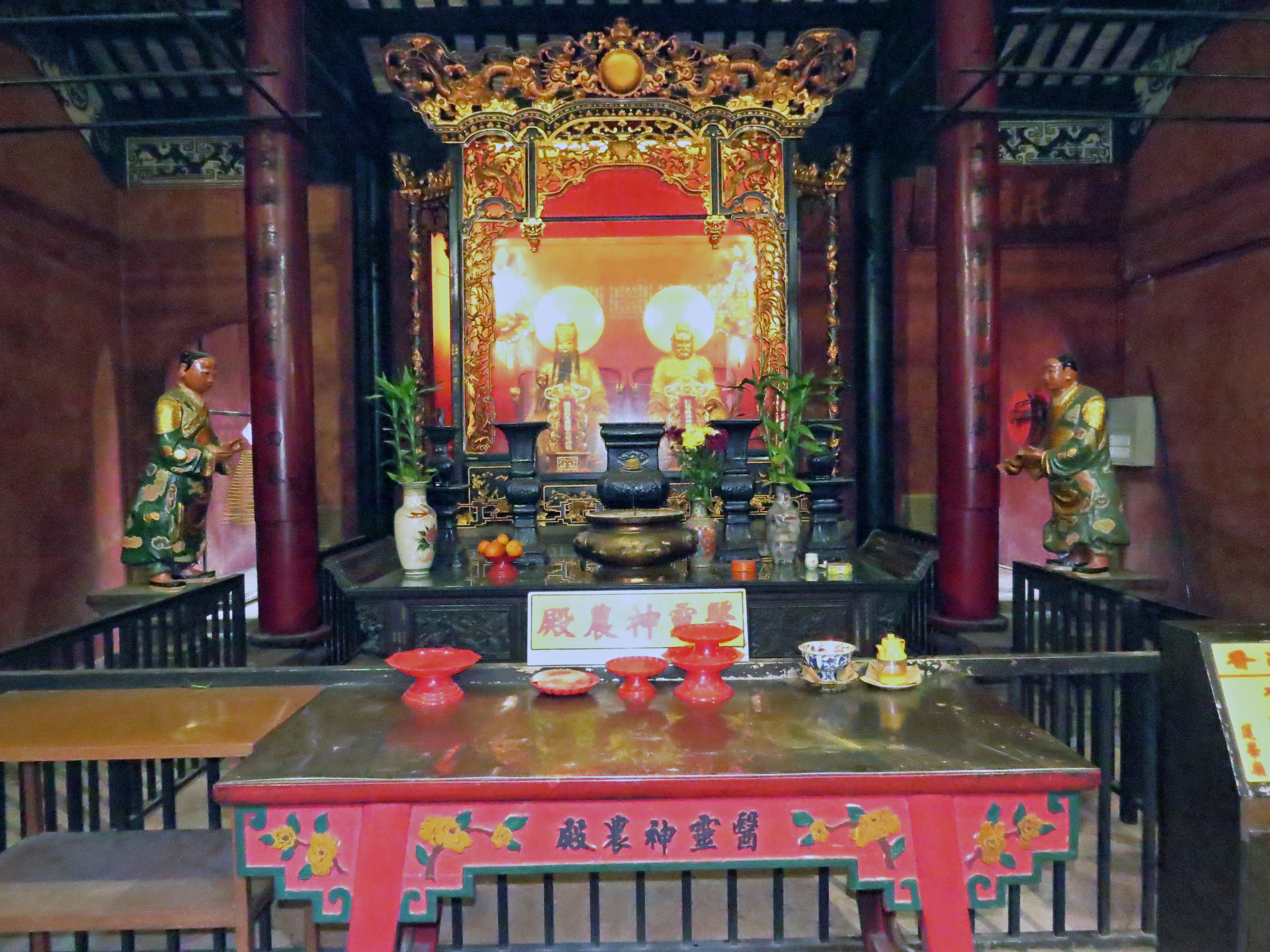 Interior de un templo chino tradicional con un altar y estatuas decorativas