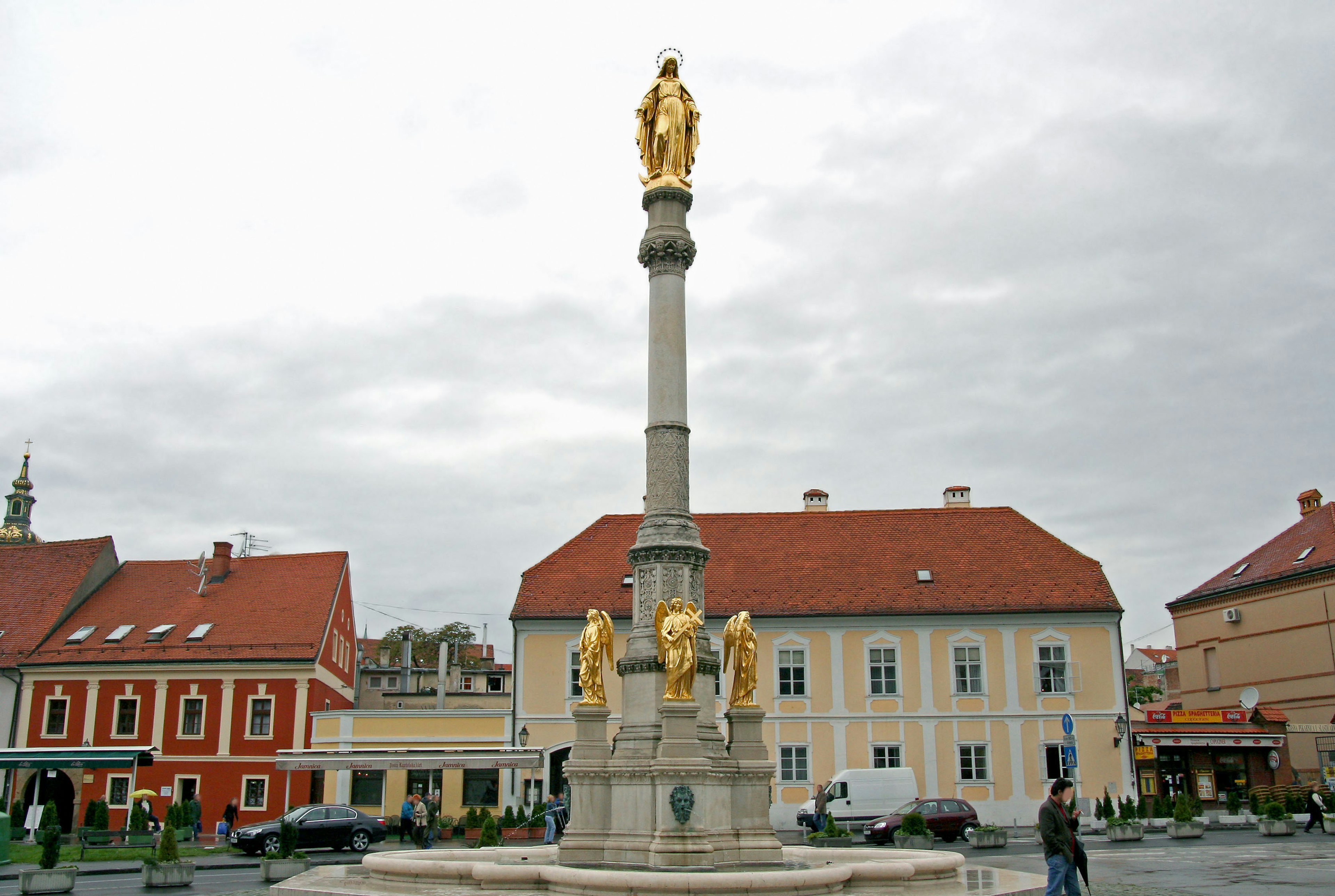 Colonna con statua dorata e edifici storici circostanti