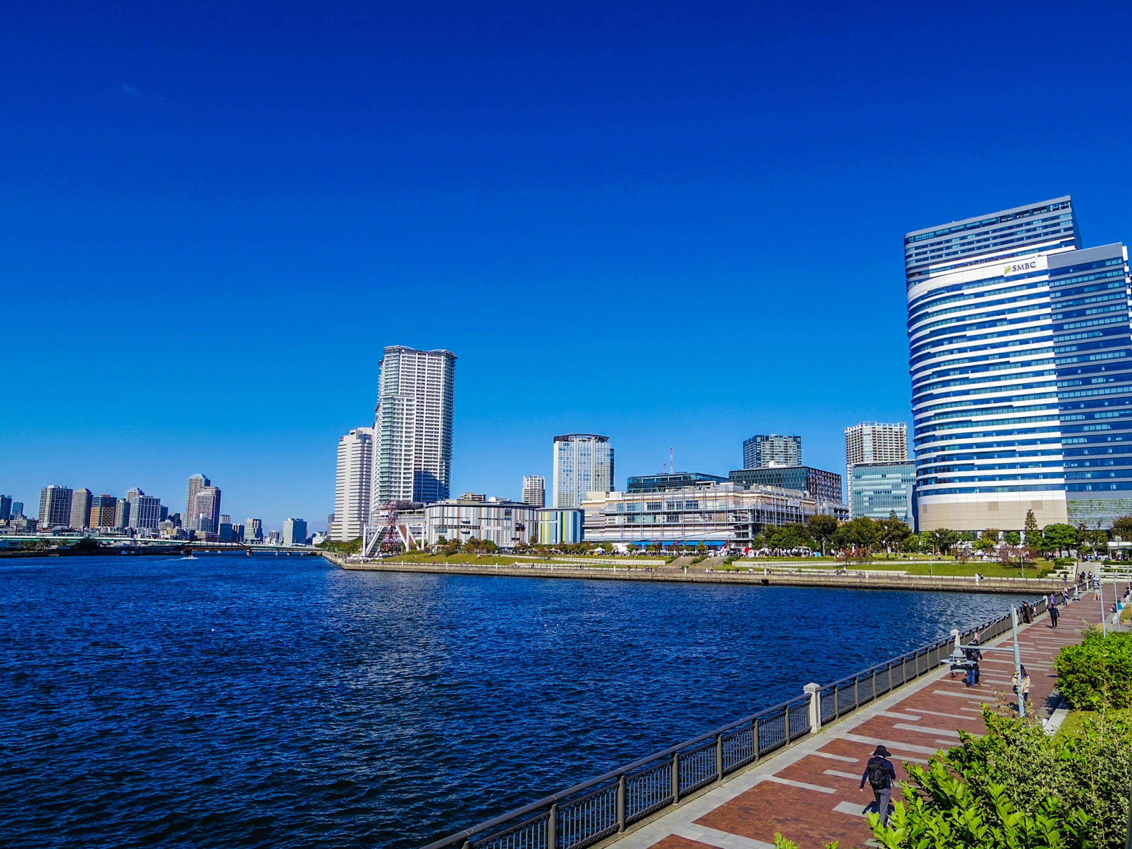 Vista panoramica sul lungomare con cielo blu e grattacieli moderni