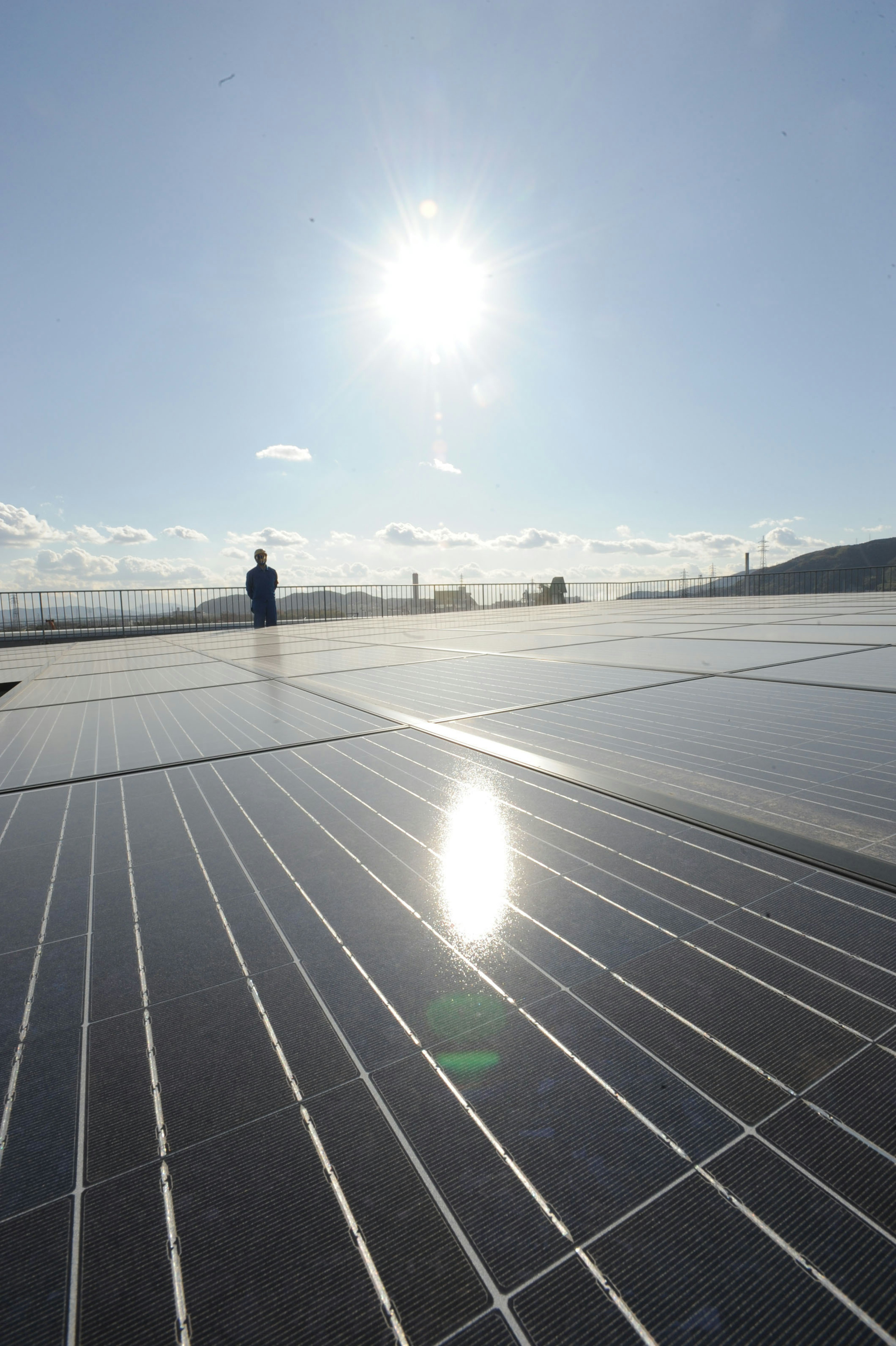 Solar panels reflecting sunlight with a silhouette of a person