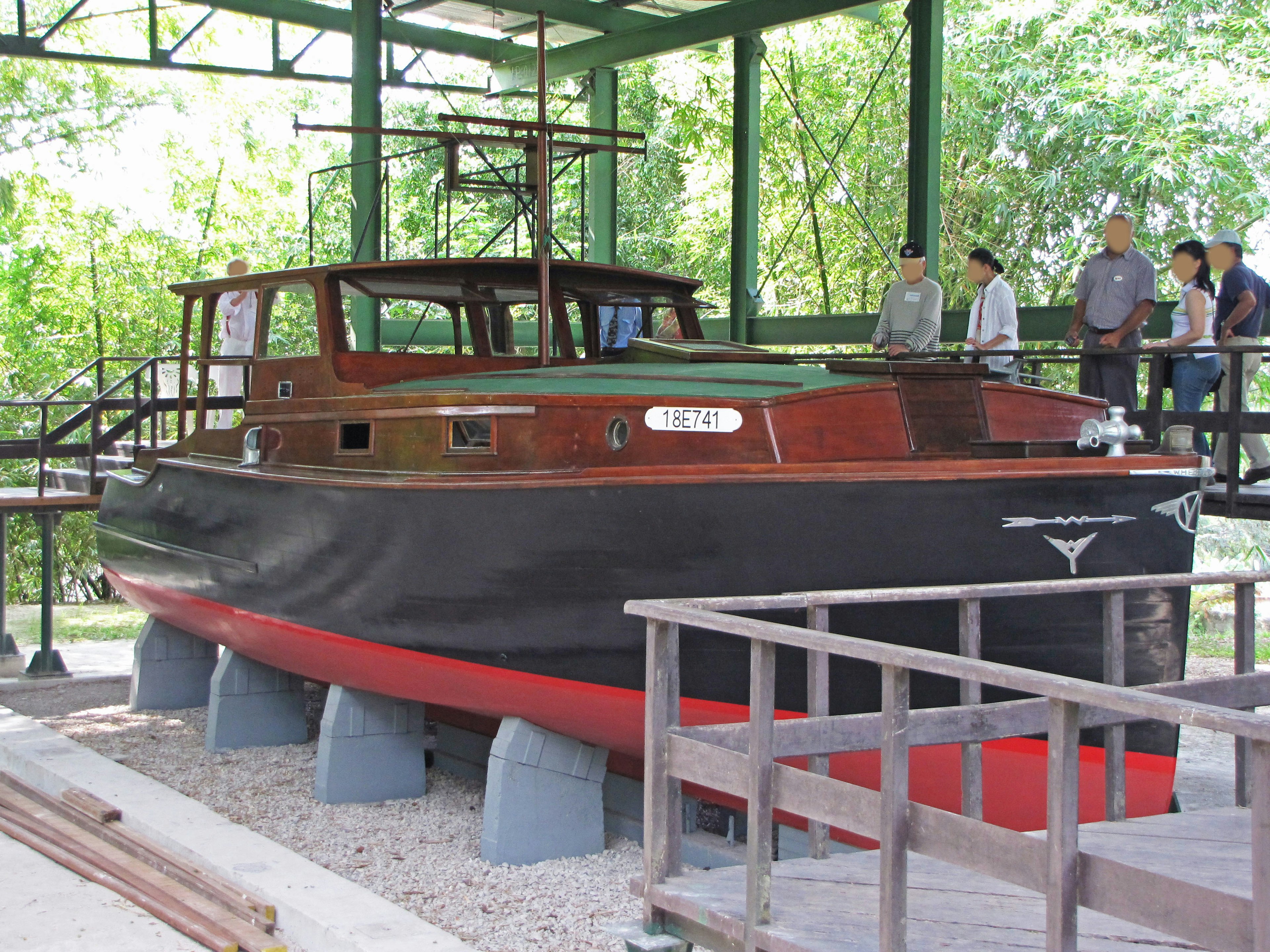 Ein Holzboot, das in einem Museum mit Besuchern in der Nähe ausgestellt ist