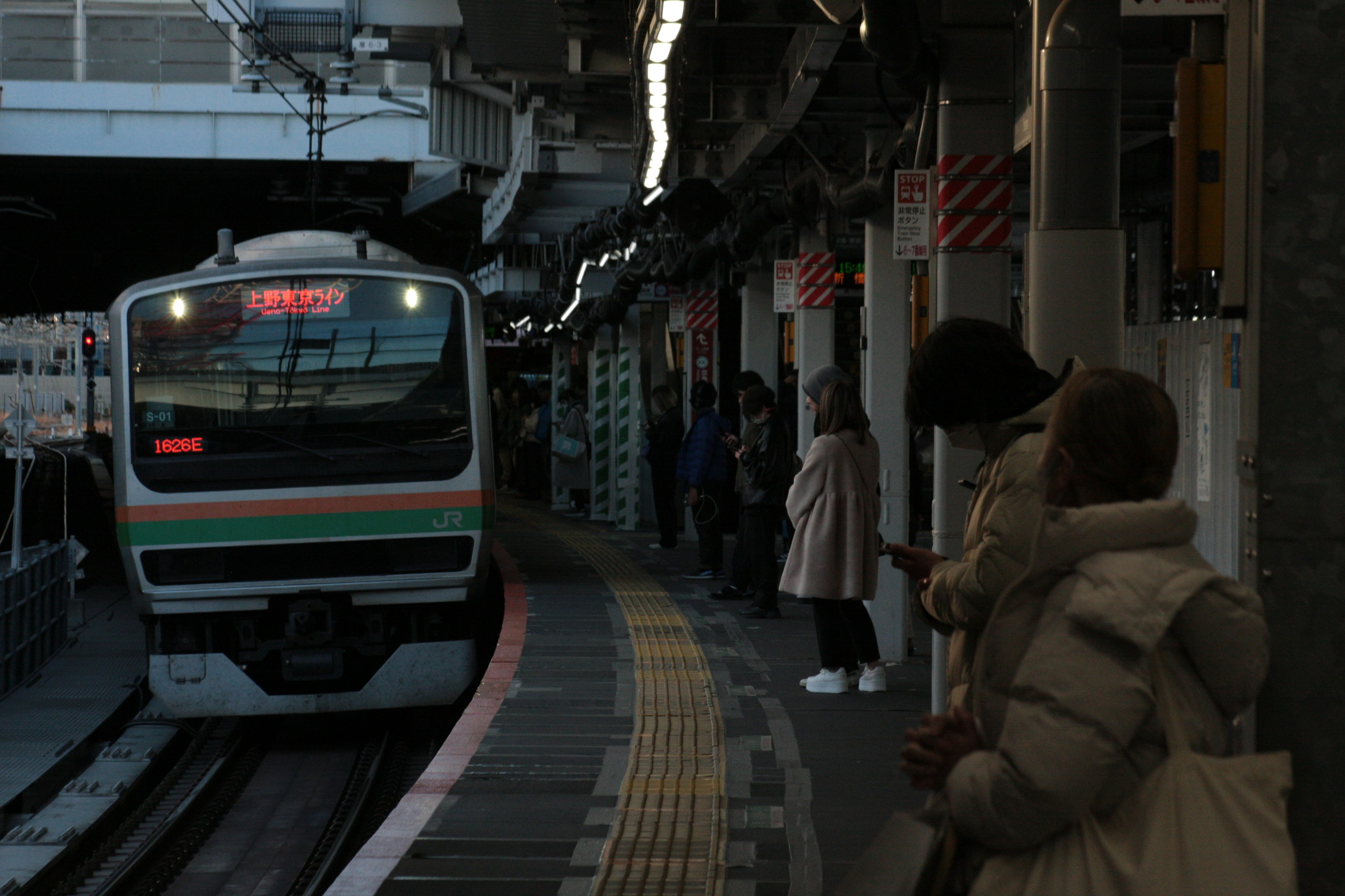 駅で待つ人々と近づく電車