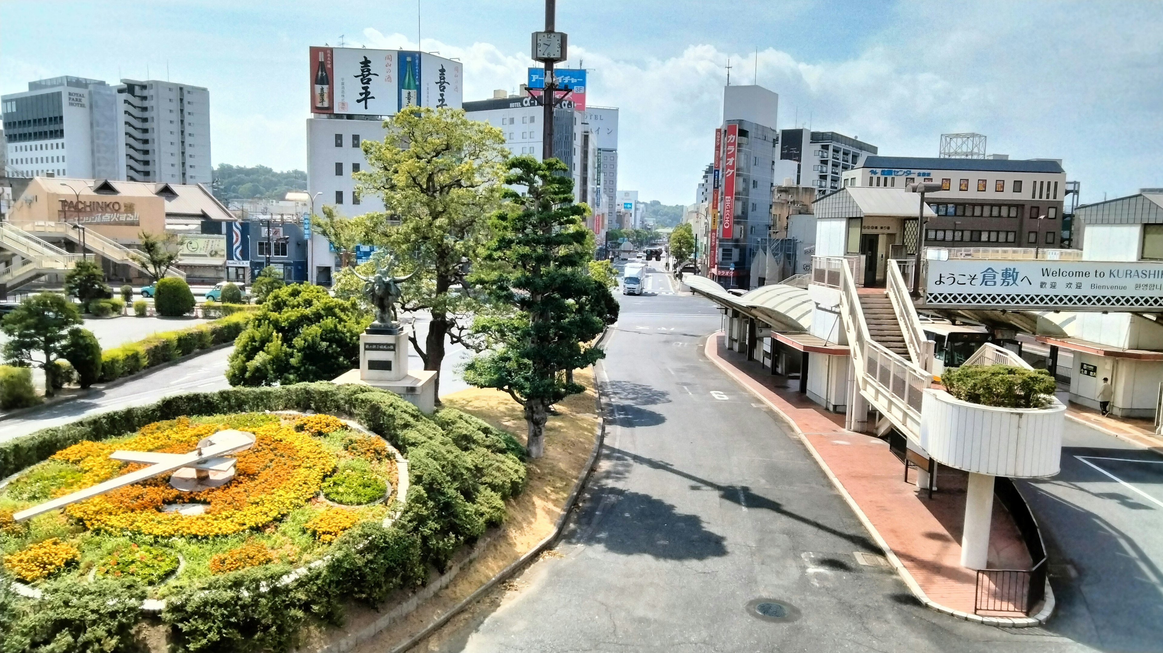 Intersection with landscaped flowerbed and city buildings